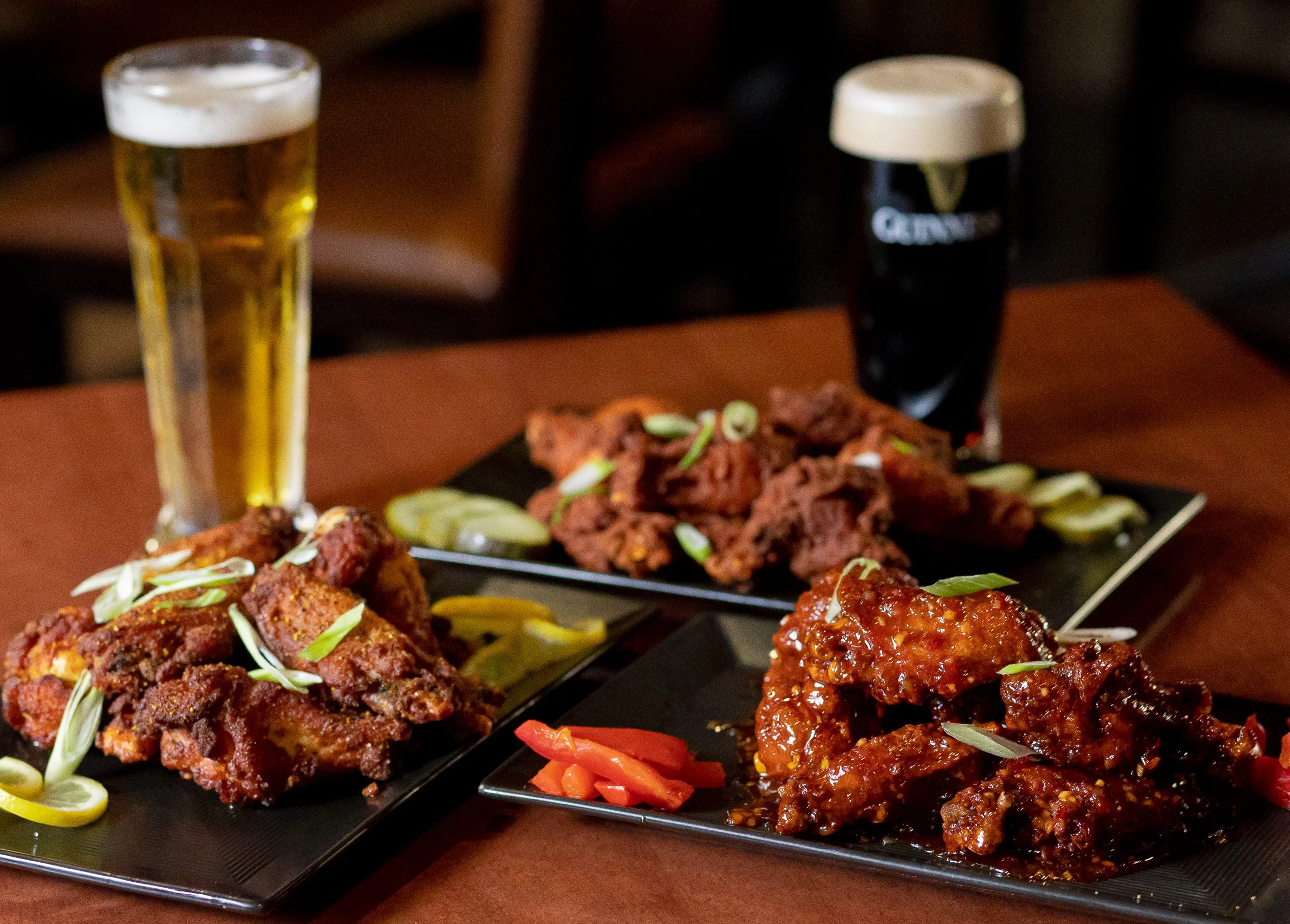 Platter of spicy chicken wings with beer in a pub setting