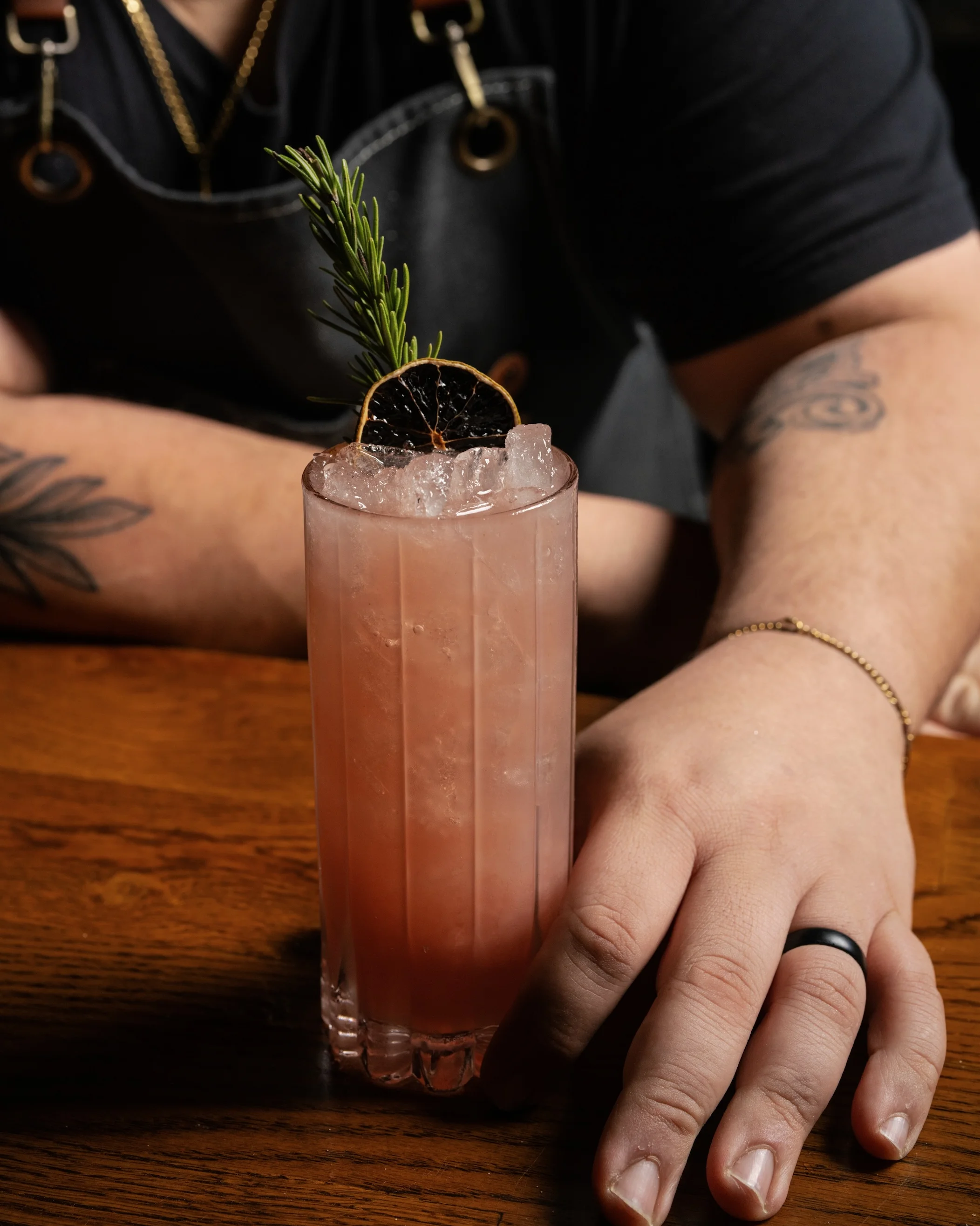 Crafted cocktail with rosemary garnish at a modern bar