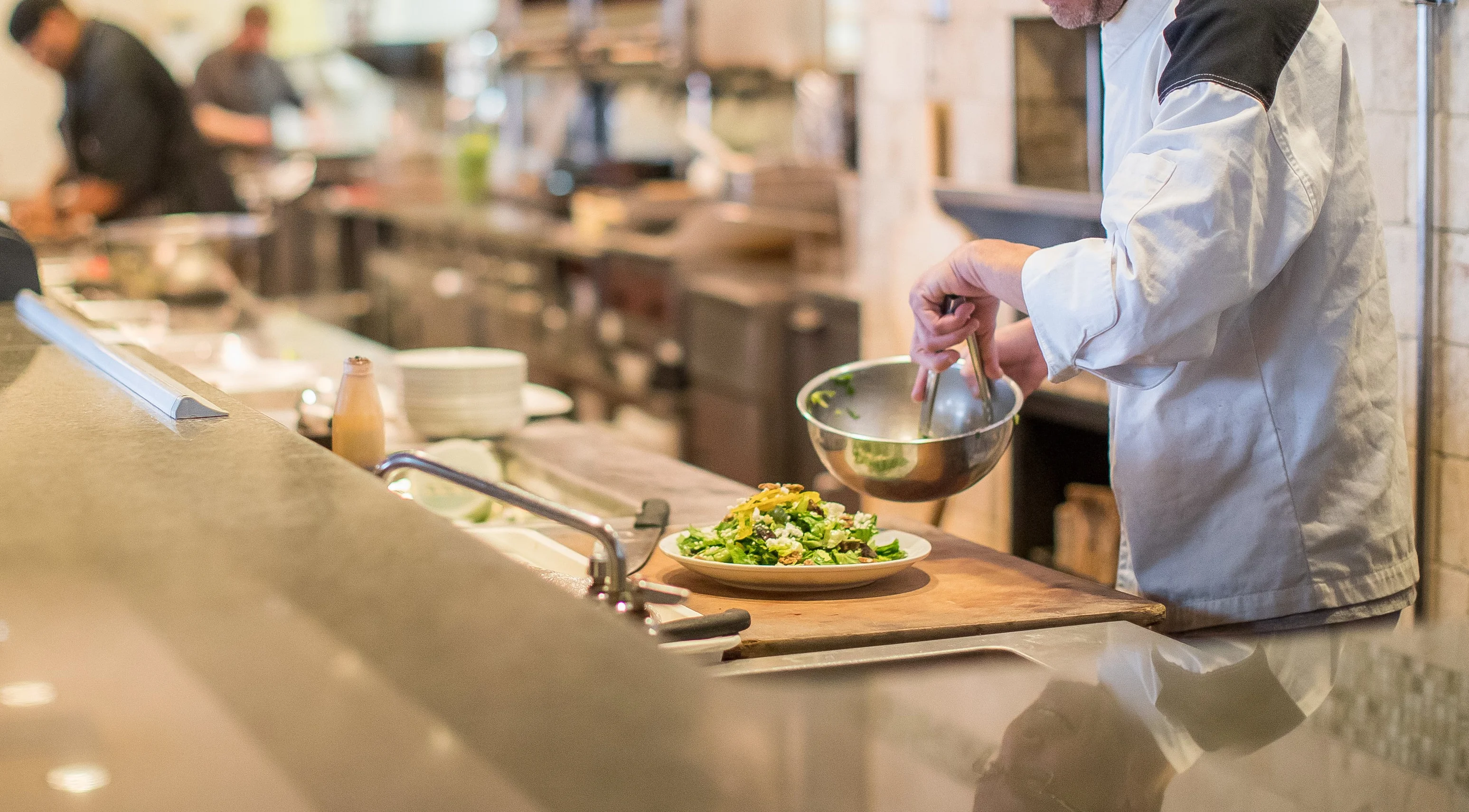 Chef preparing a fresh salad in a modern kitchen