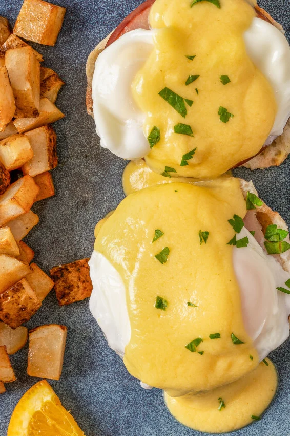 Classic Eggs Benedict with hollandaise sauce and breakfast potatoes