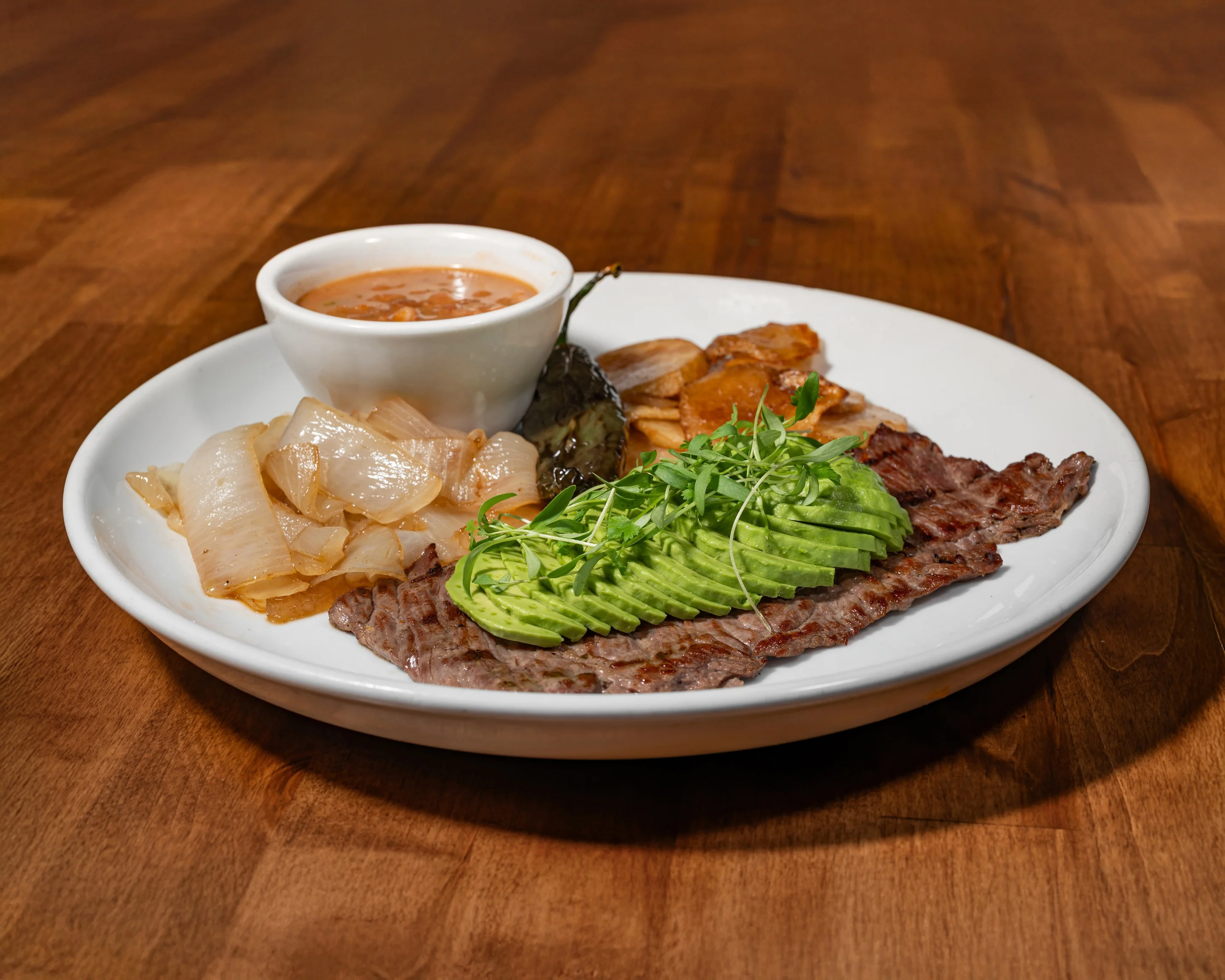 An assortment of Mexican dishes including grilled meats, tortillas, beans, and sauces, arranged in a vibrant and colorful setting.