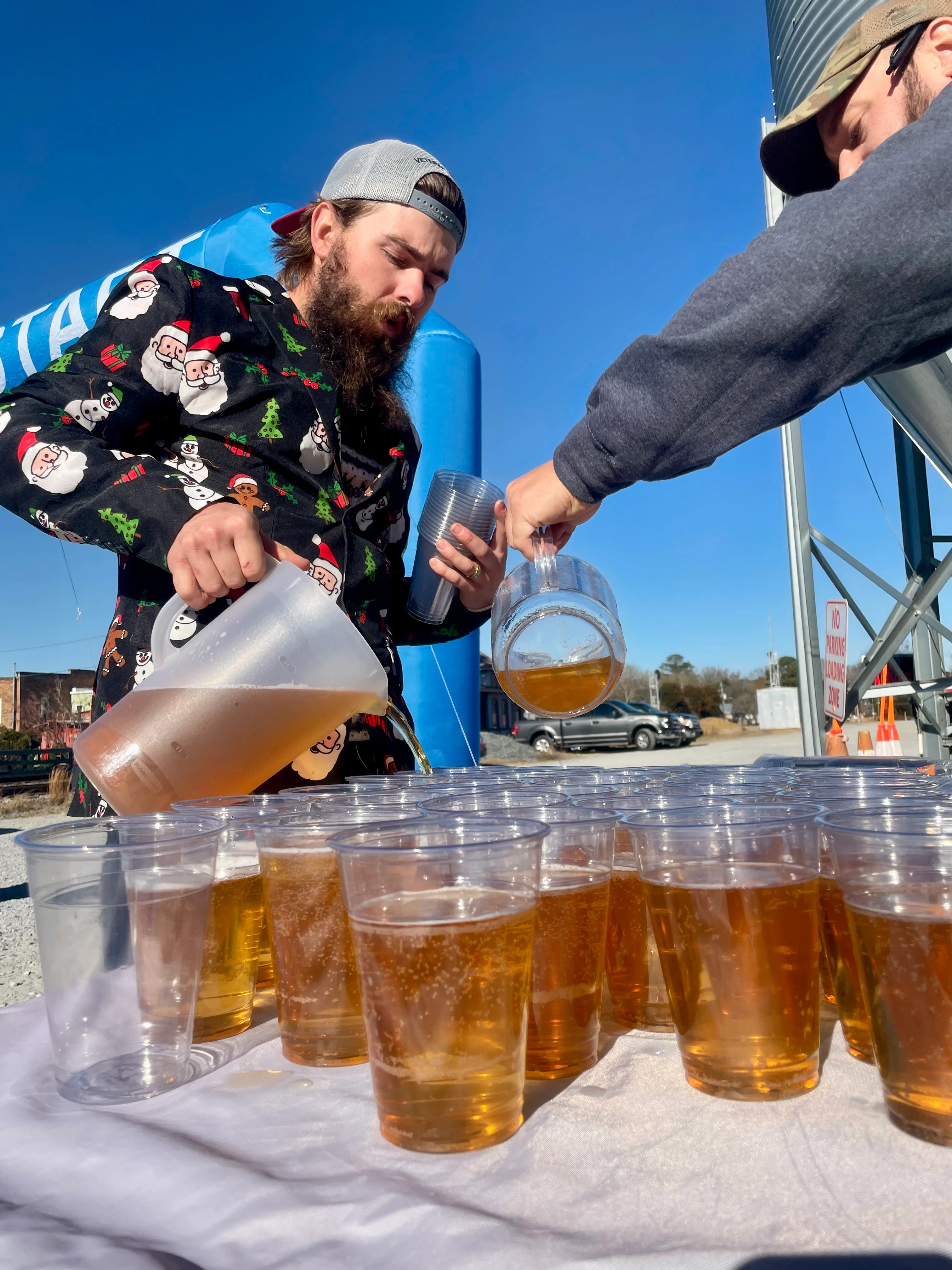 Pouring craft beer into cups at an outdoor event