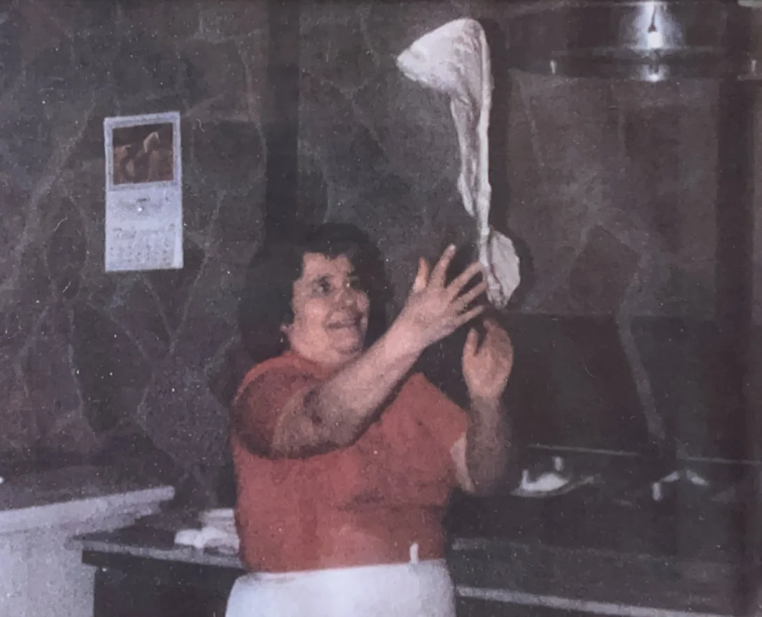Experienced chef preparing pizza dough in a bustling kitchen