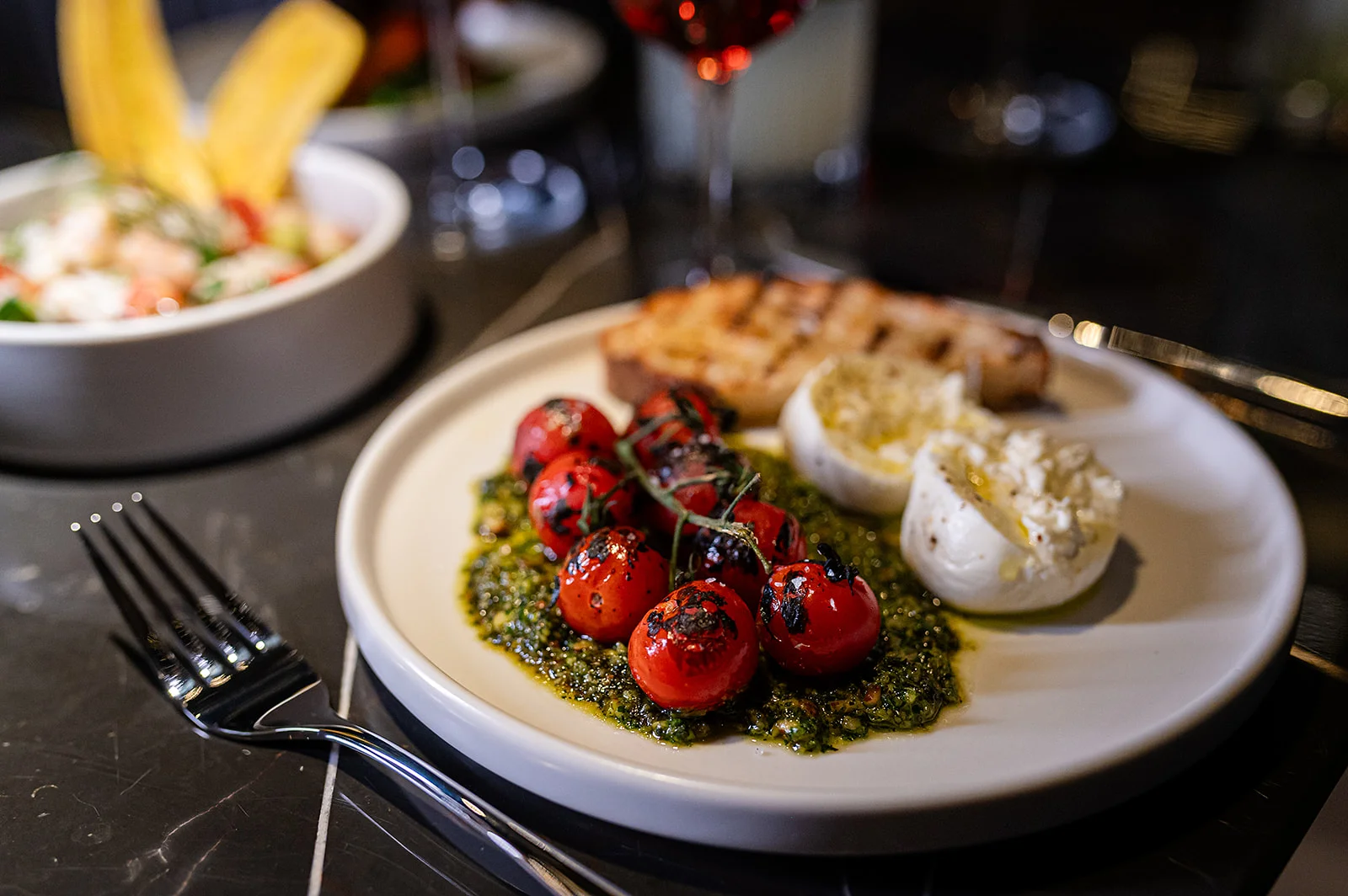 Grilled cherry tomatoes with pesto and burrata, Italian appetizer