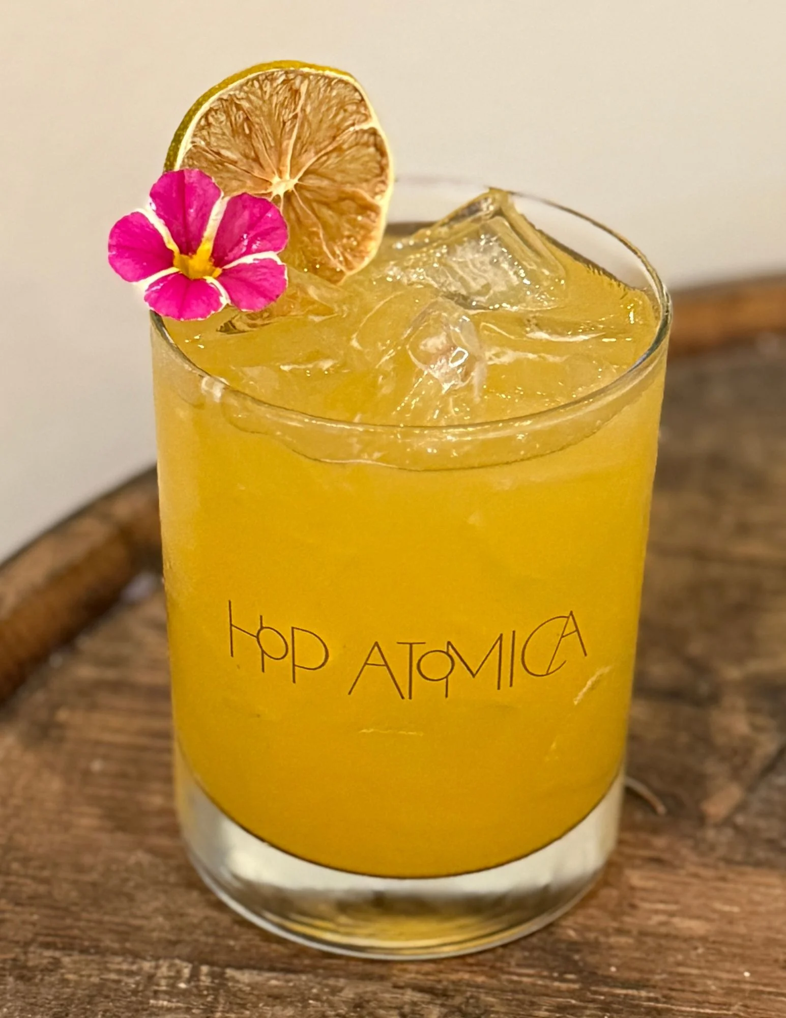 Craft cocktail with dried orange garnish on a wooden table