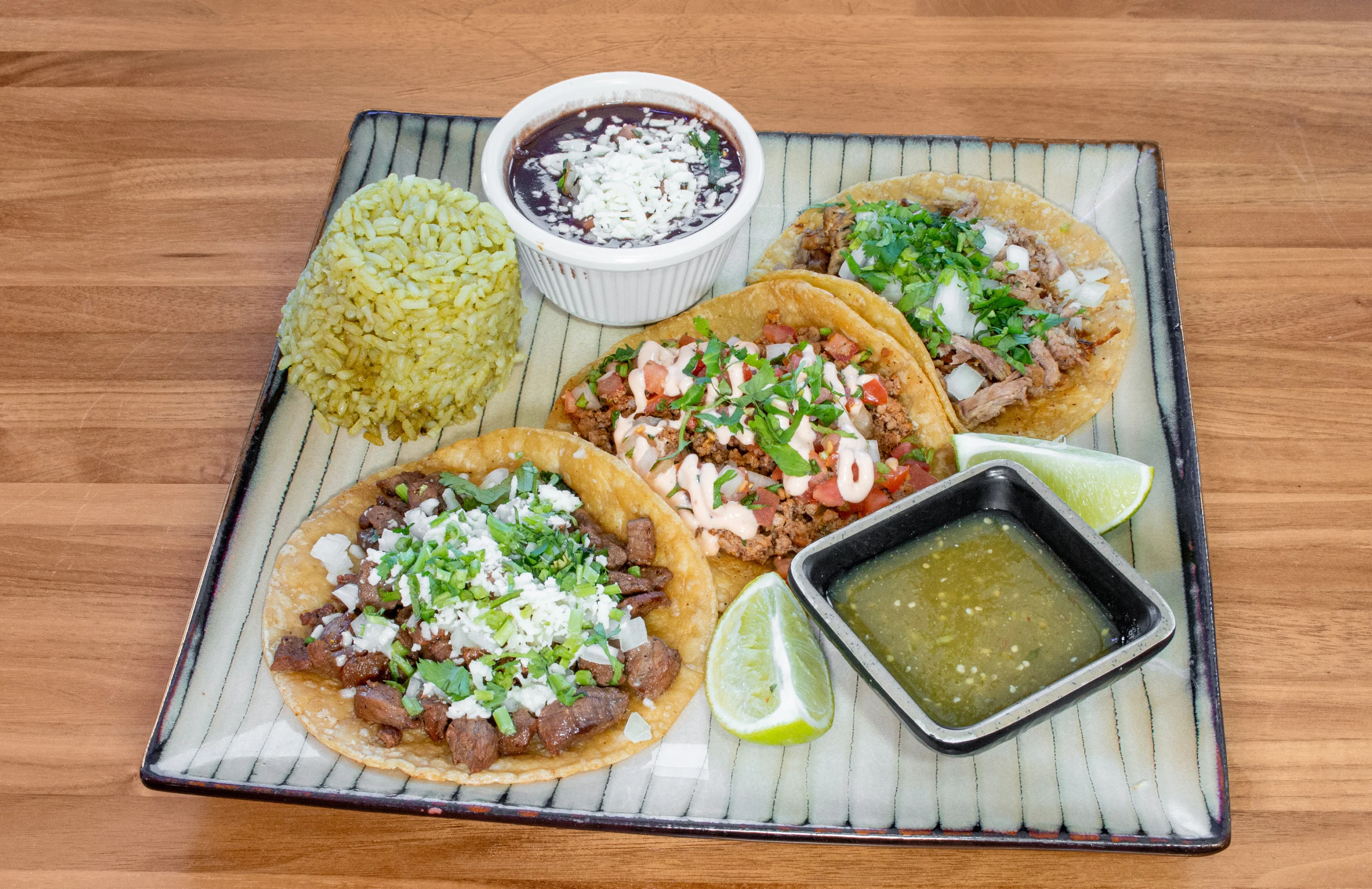 Authentic Mexican tacos with rice and beans on a decorative plate