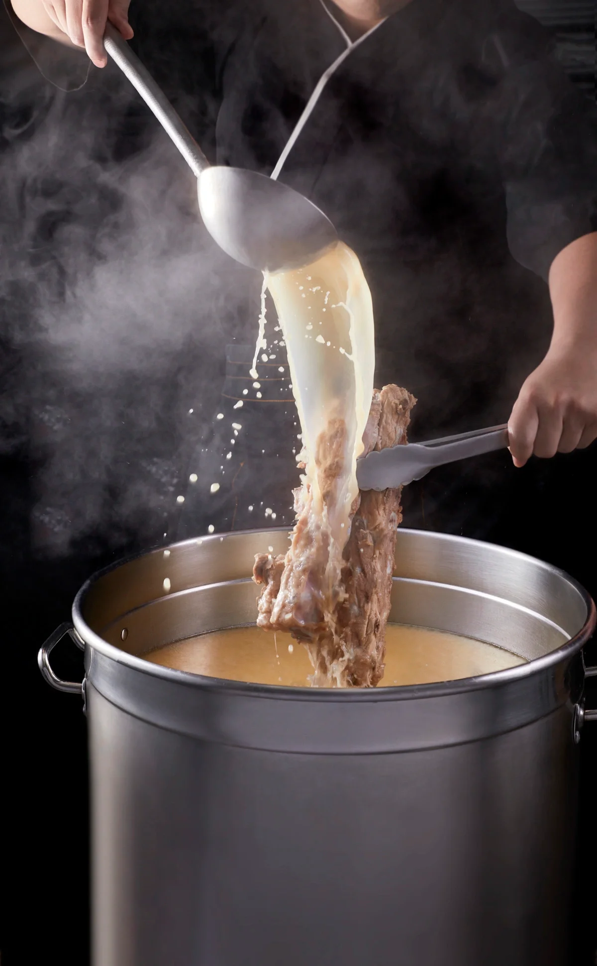 Chef pouring rich broth for traditional ramen