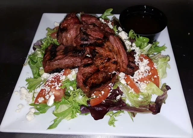 Grilled steak salad with mixed greens and dressing
