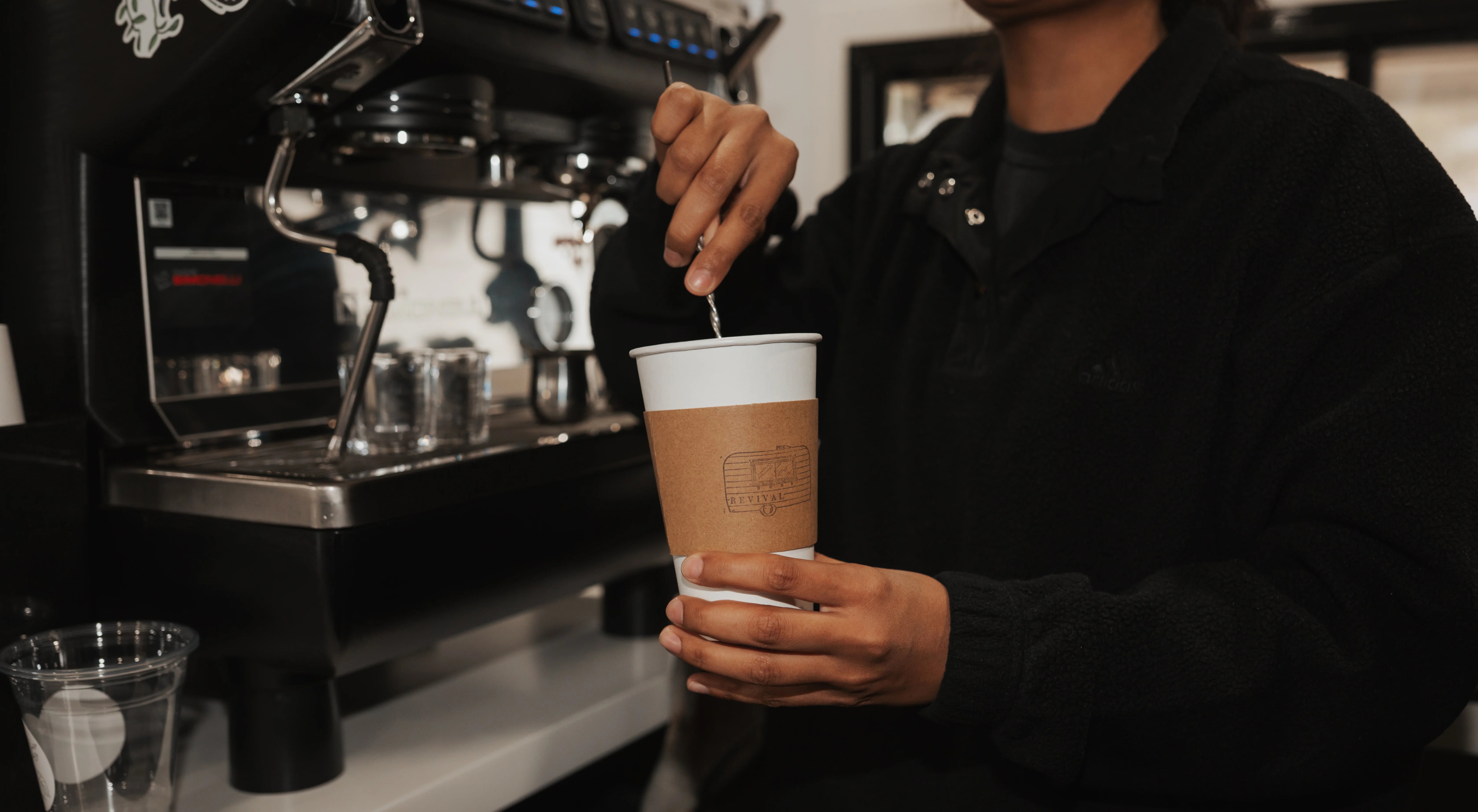 Barista stirring syrup into espresso.