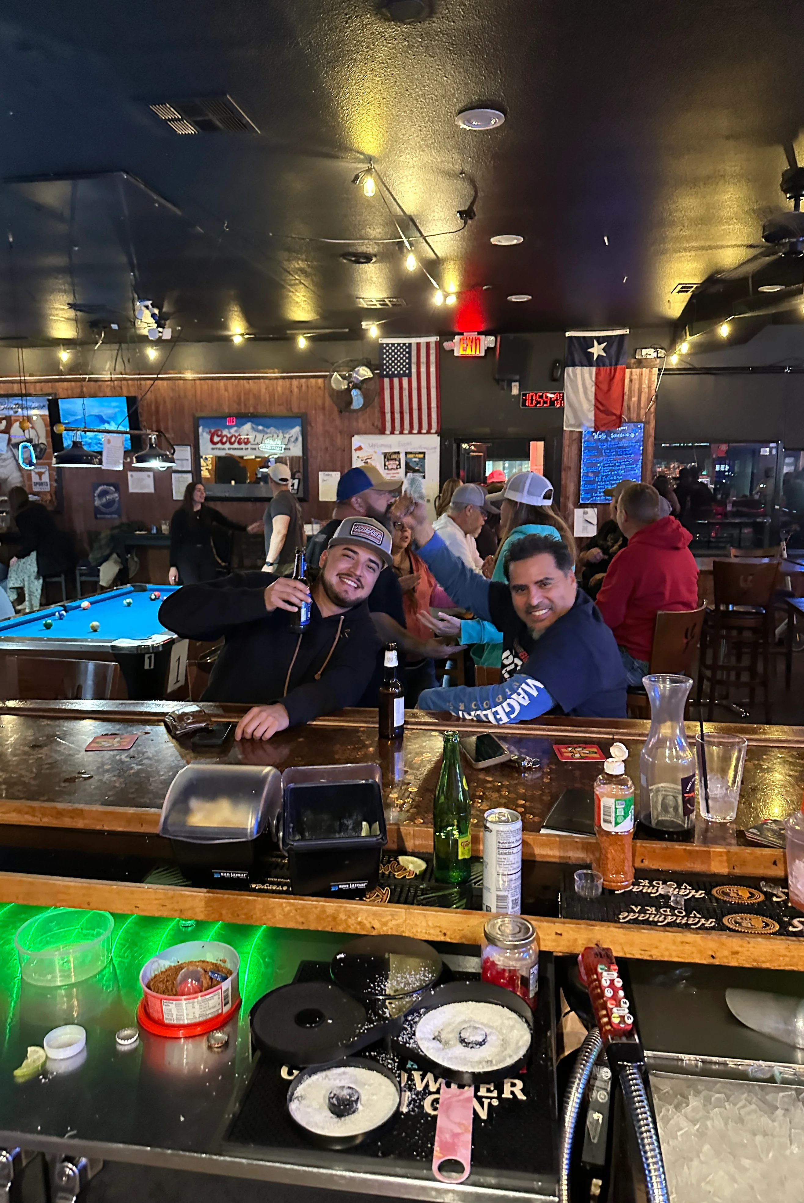 Lively bar scene with patrons enjoying drinks and playing pool