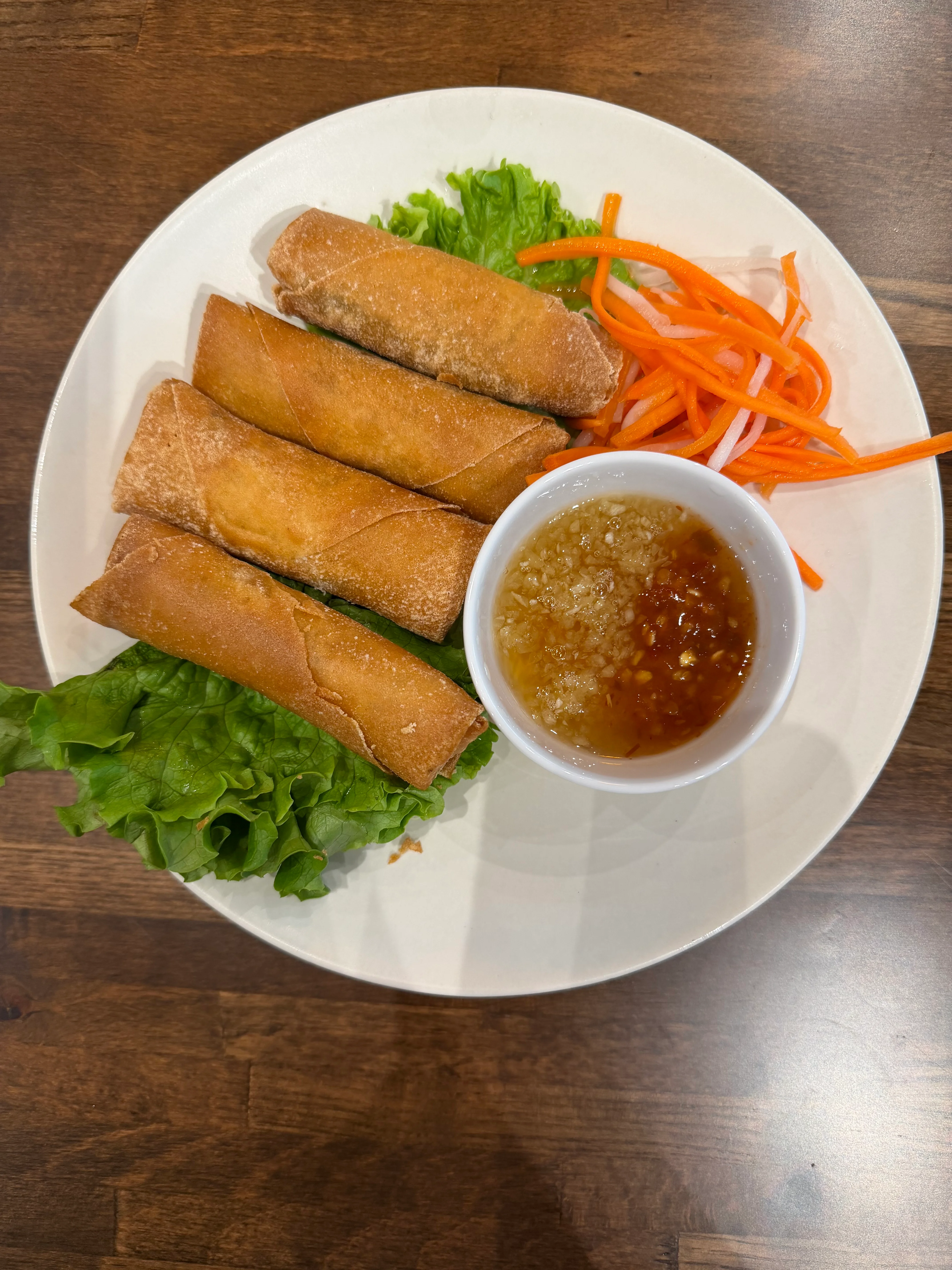 Crispy Vietnamese spring rolls with dipping sauce and fresh vegetables