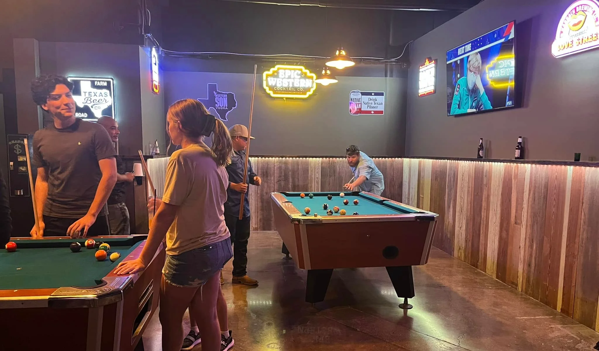 Social gathering at a lively pool hall with friends playing billiards