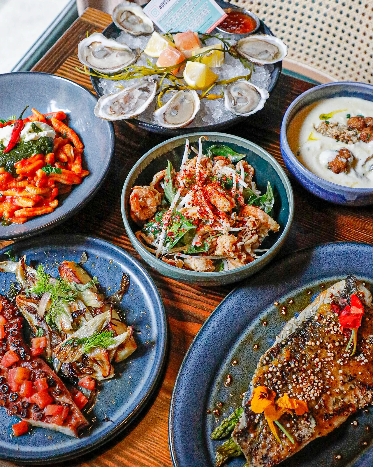 Assorted seafood dishes including oysters and grilled fish