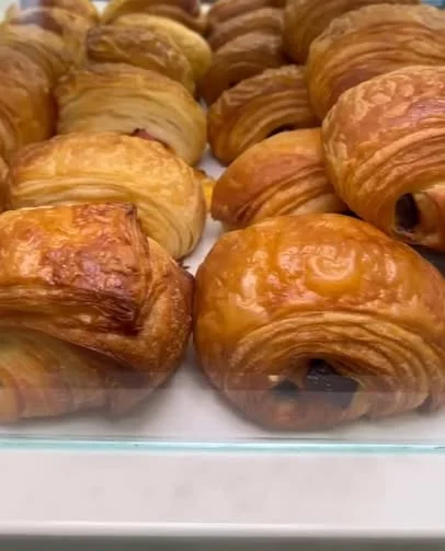 Freshly baked French croissants in a display case