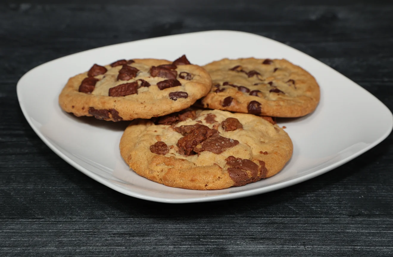 A plate of freshly baked cookies with chocolate chips.