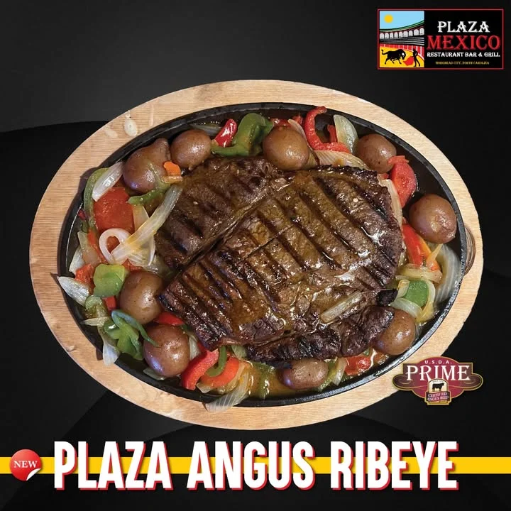 A sizzling platter of Angus ribeye steak served with assorted sautéed vegetables and small potatoes.
