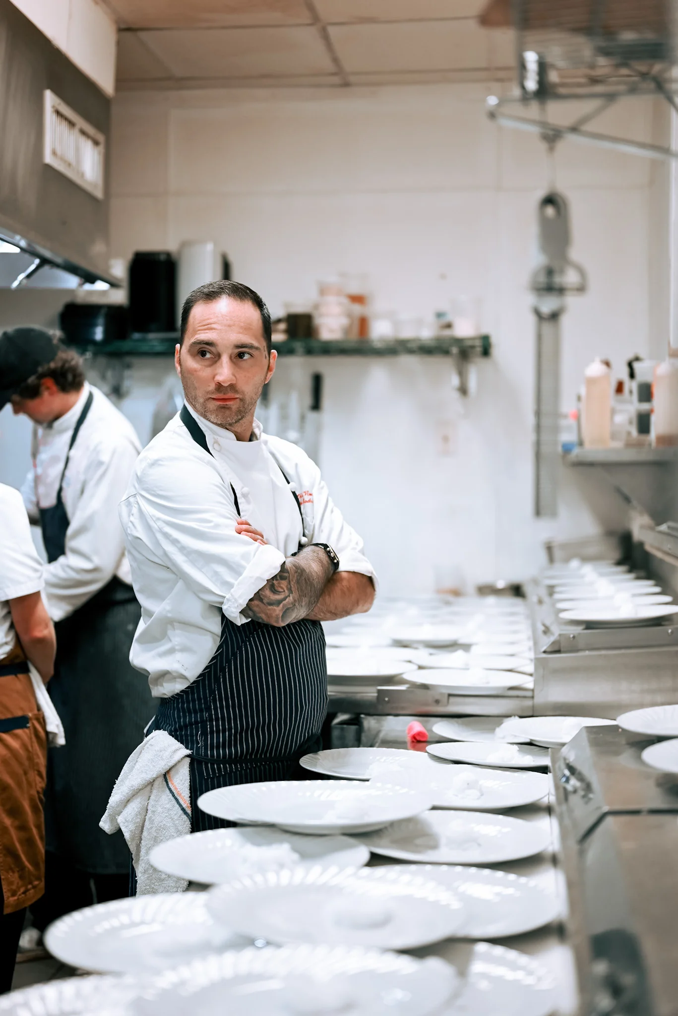 Chef overseeing a busy kitchen with plates ready for service