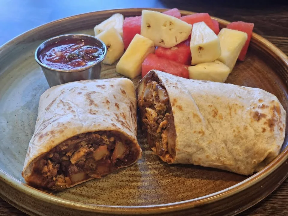 Delicious breakfast burrito with salsa and fresh fruit
