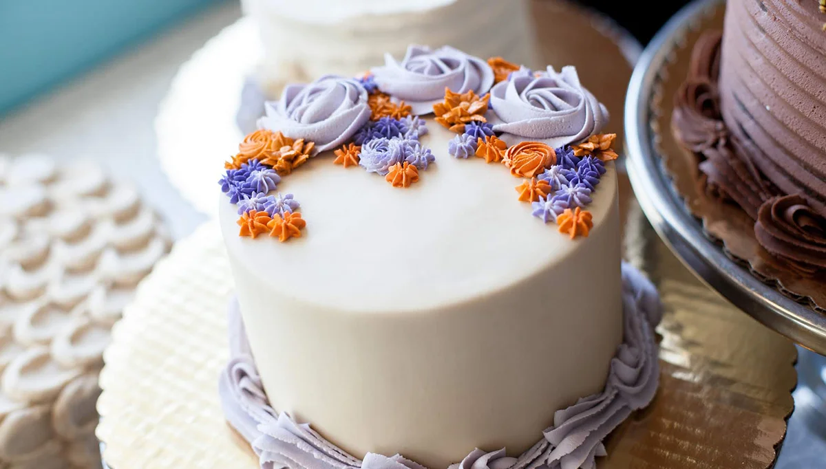 Decorative floral cake with purple and orange icing
