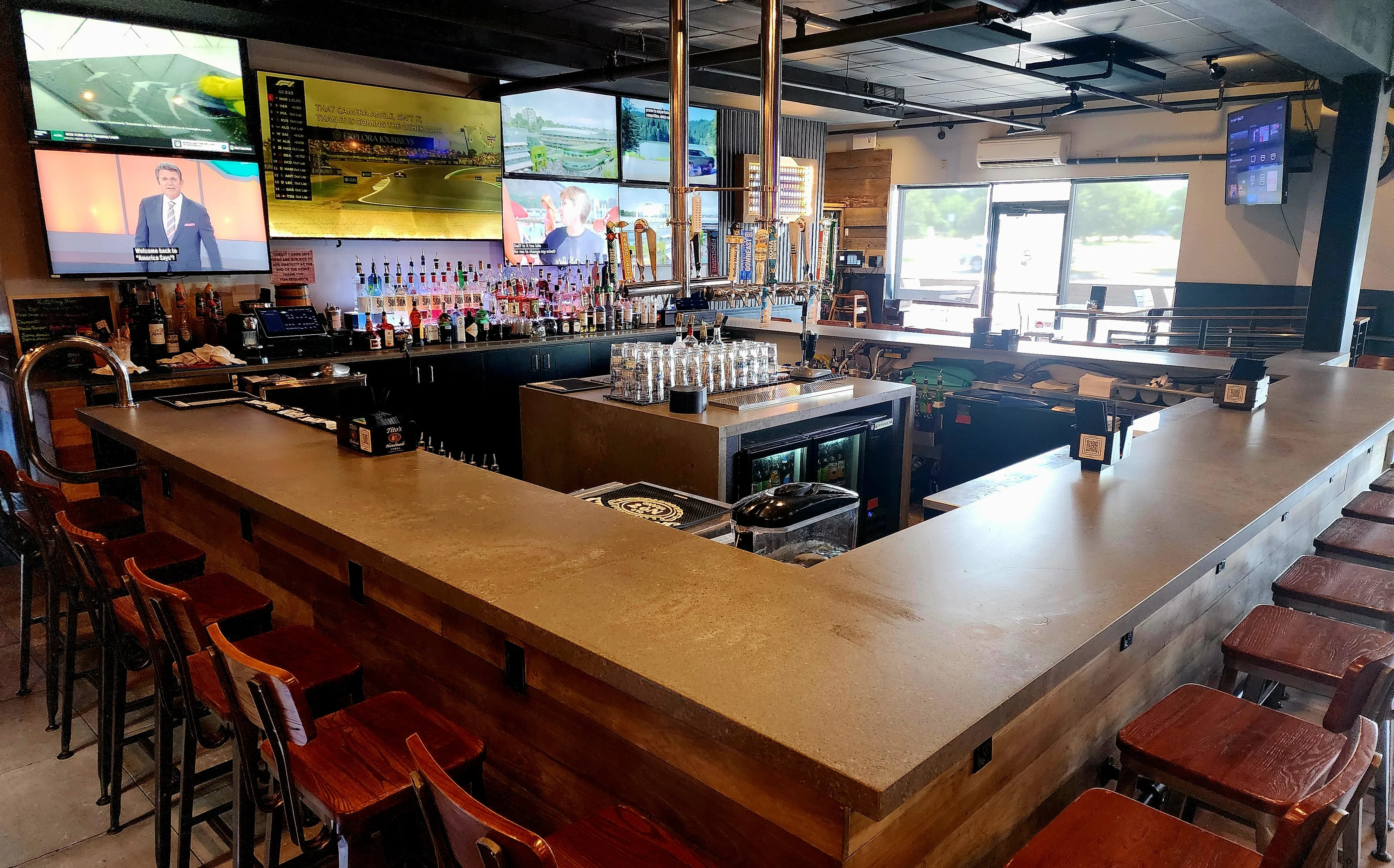 Modern bar interior with multiple screens and a sleek counter