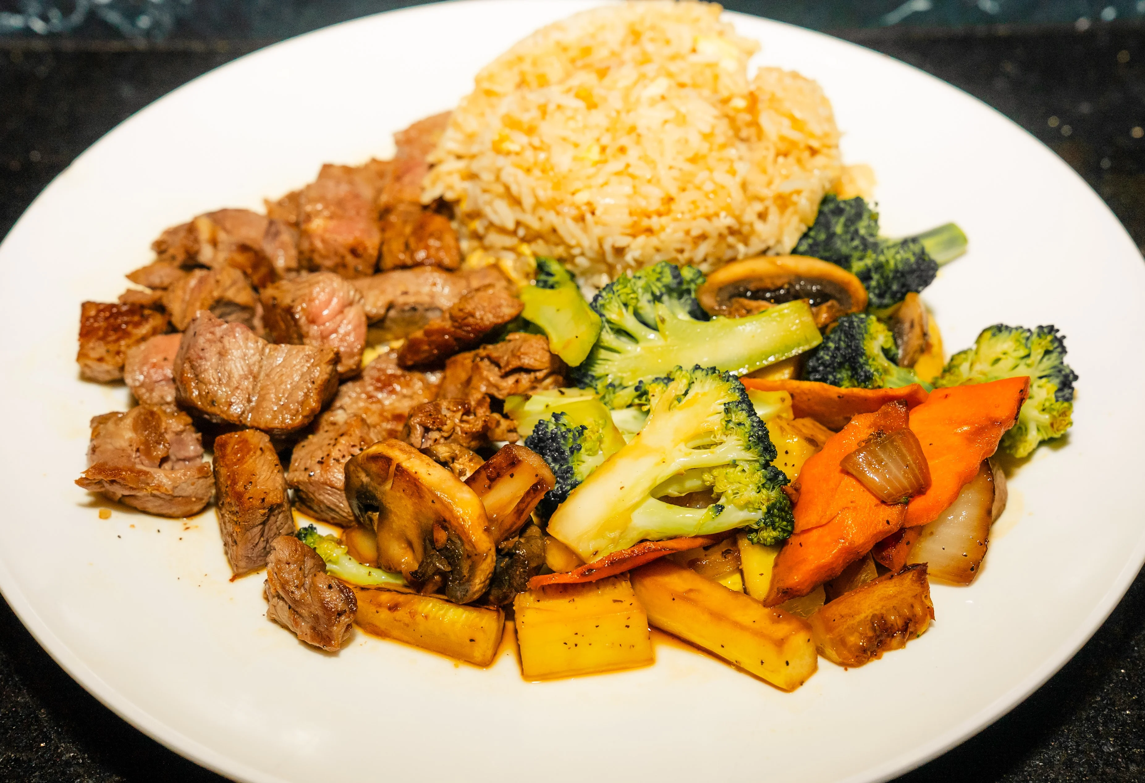 Sizzling hibachi steak with fried rice and mixed vegetables