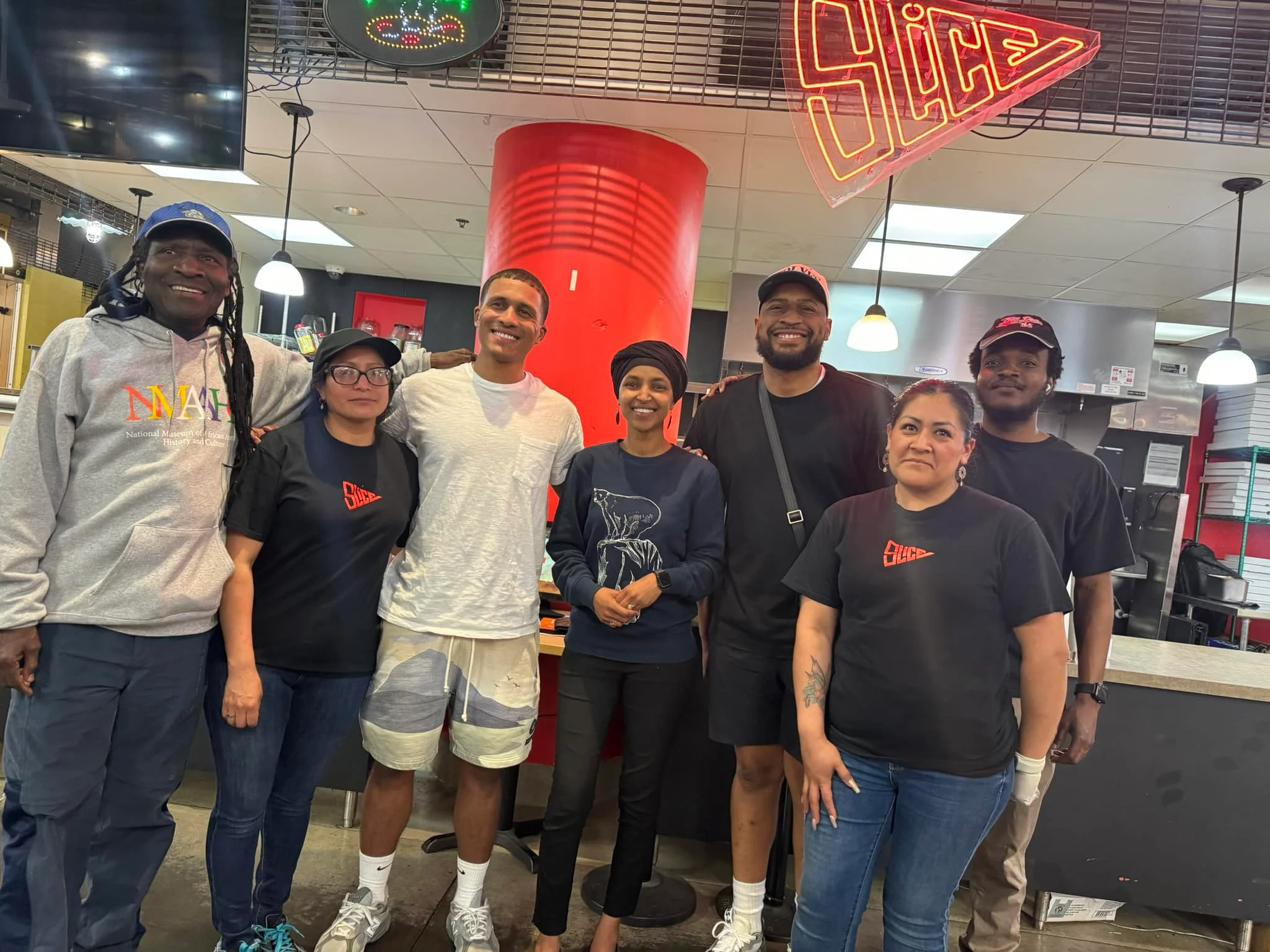 Team of restaurant staff posing in front of Slice pizzeria