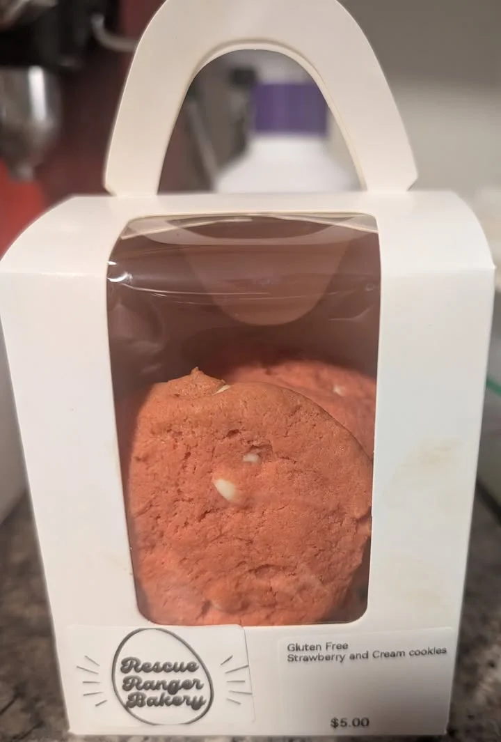 Gluten-free strawberry cream cookies in a bakery box