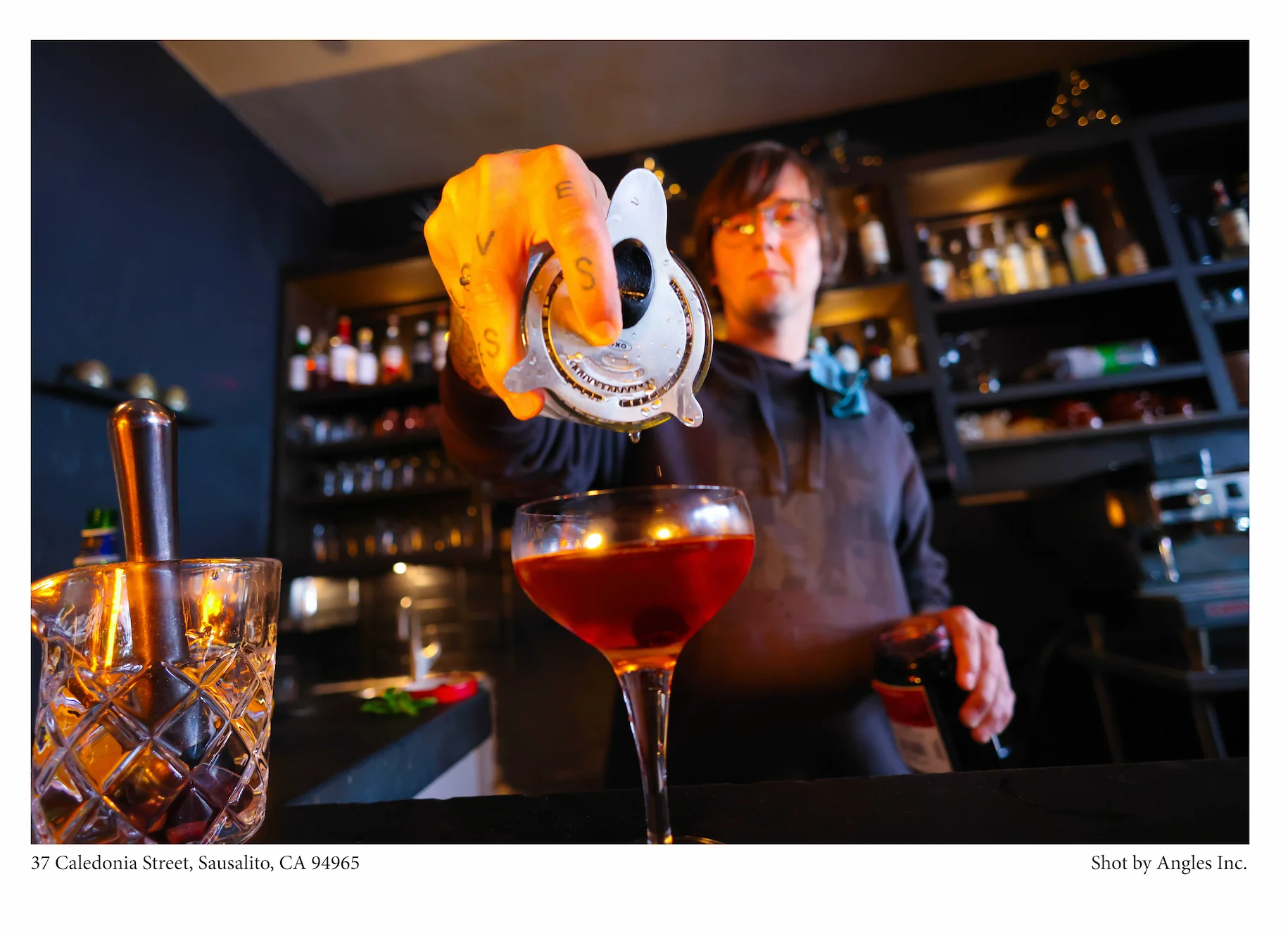 Bartender pouring a cocktail at a stylish bar