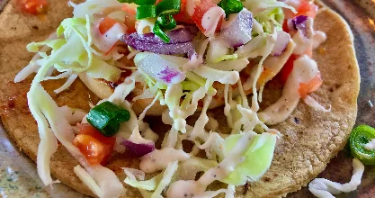 Delicious fish taco topped with fresh vegetables