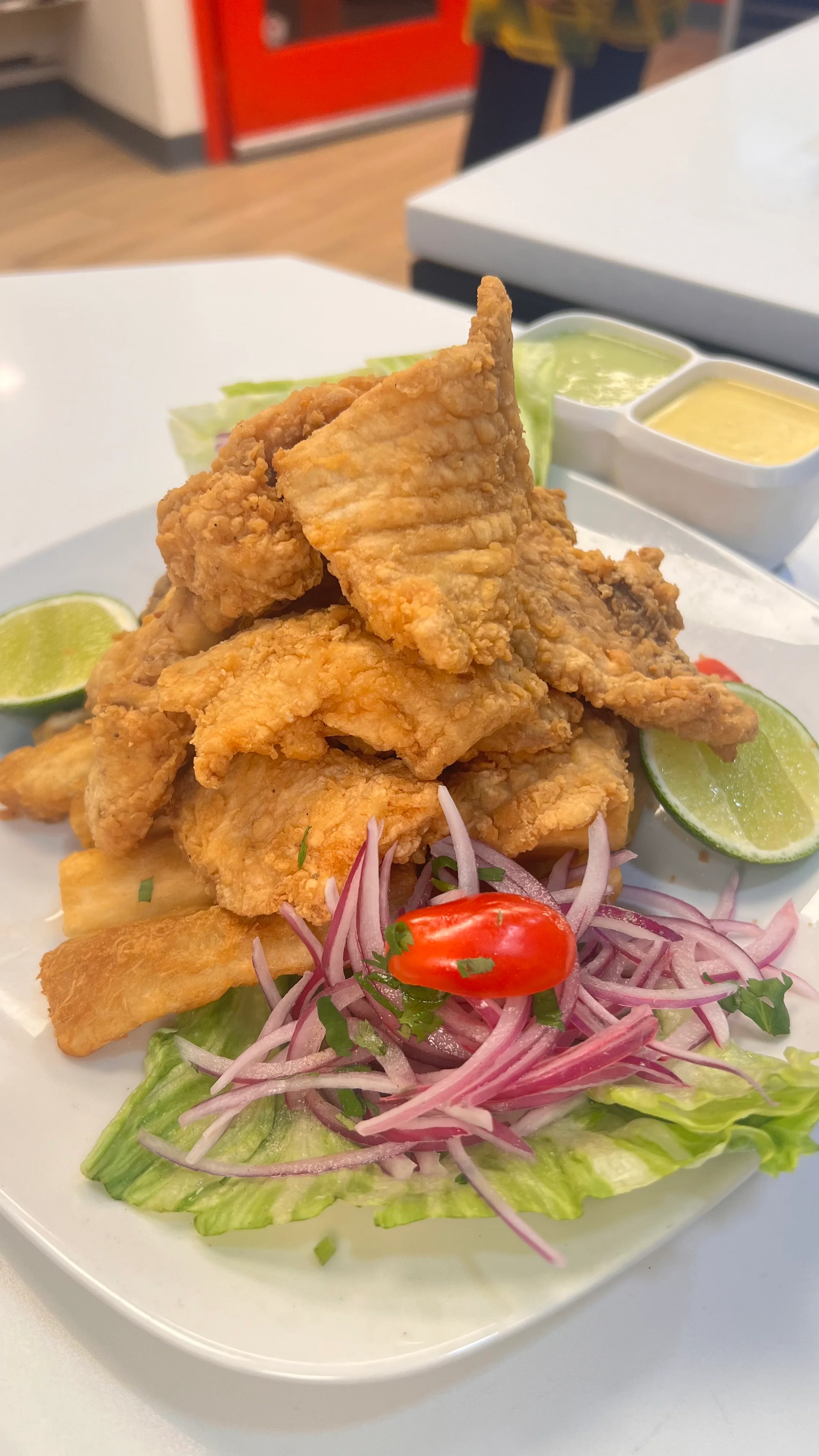 Crispy fried fish with plantains and salad, a popular Latin American dish