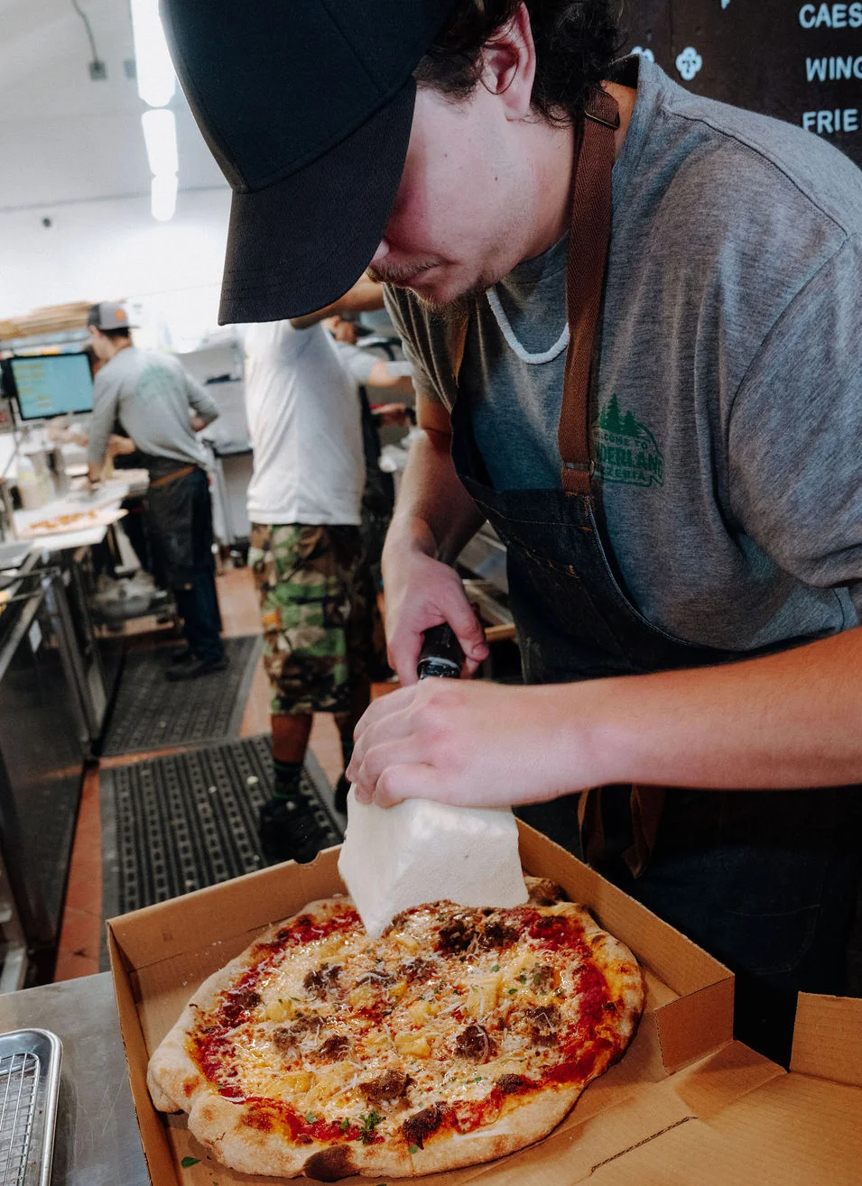 A line cook preparing food in a restaurant kitchen.