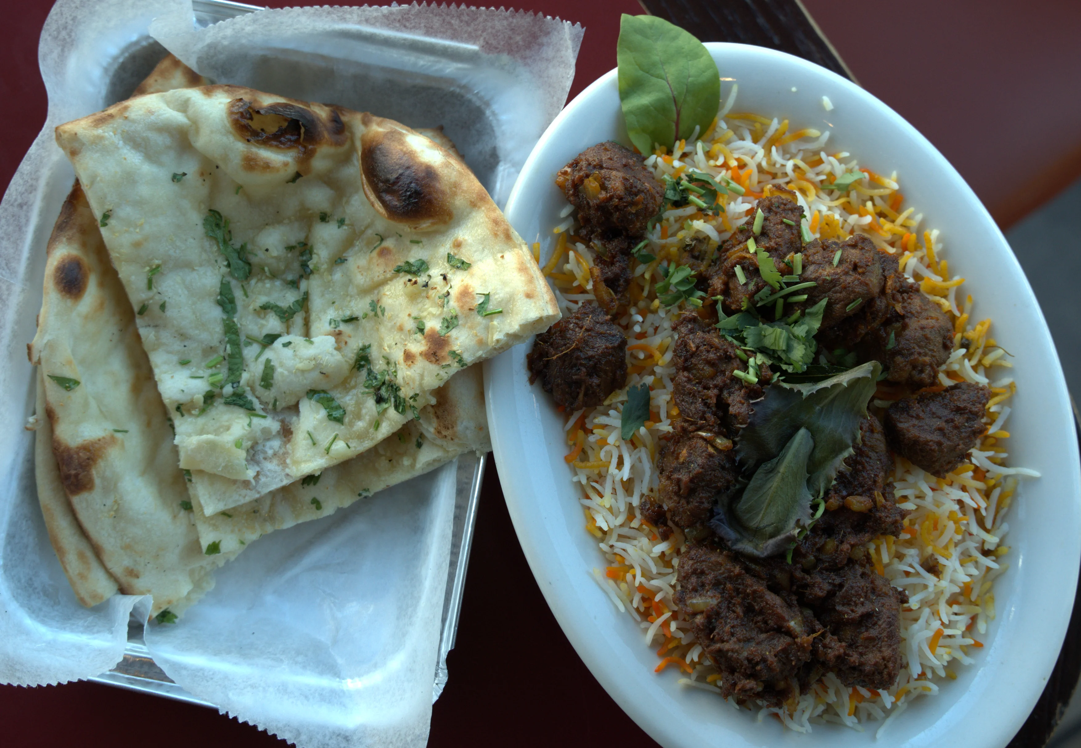 Biryani served with garlic naan in a vibrant restaurant setting