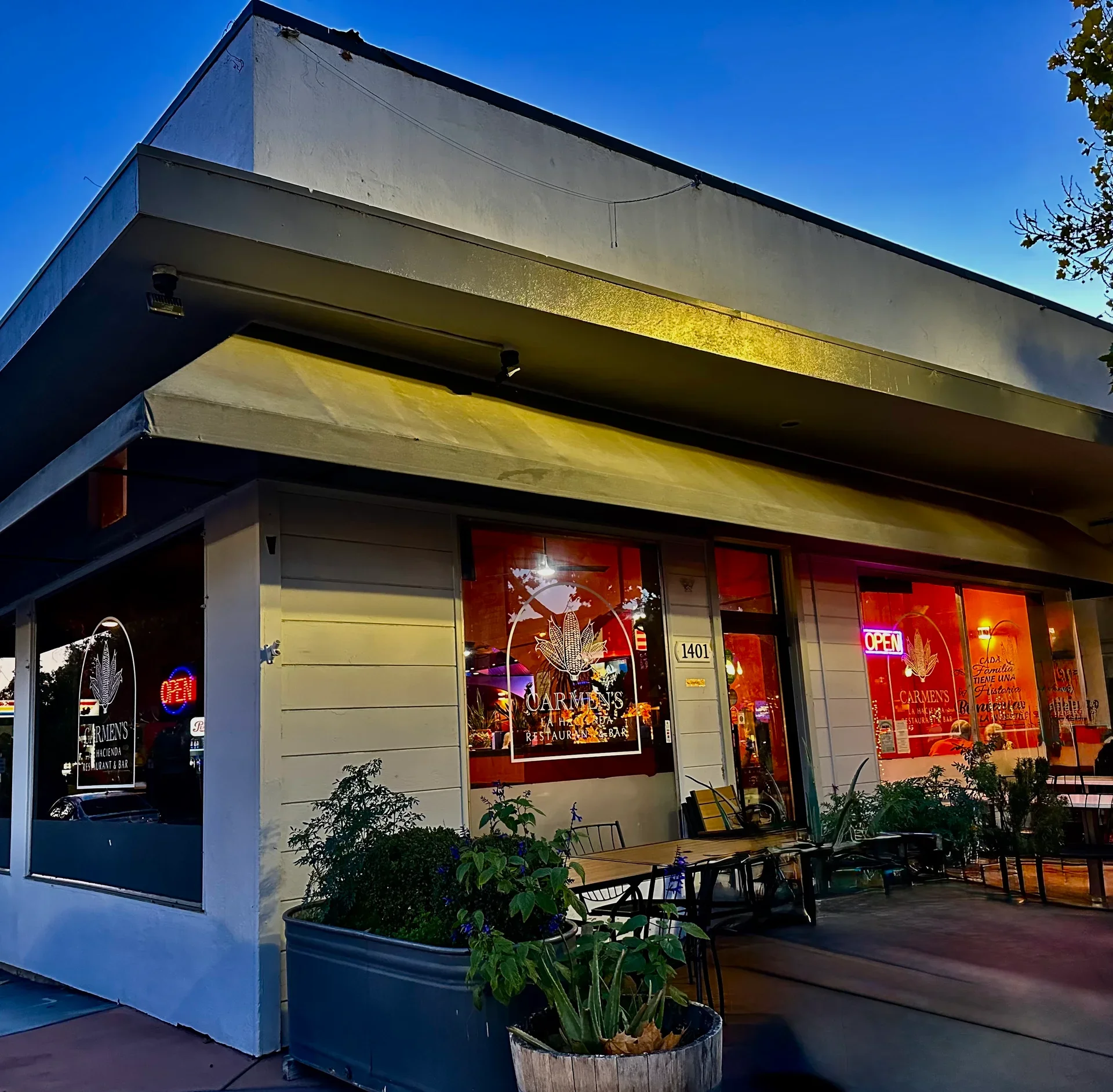 The exterior of a Mexican restaurant featuring illuminated signs and a stone facade, welcoming visitors in the evening light.