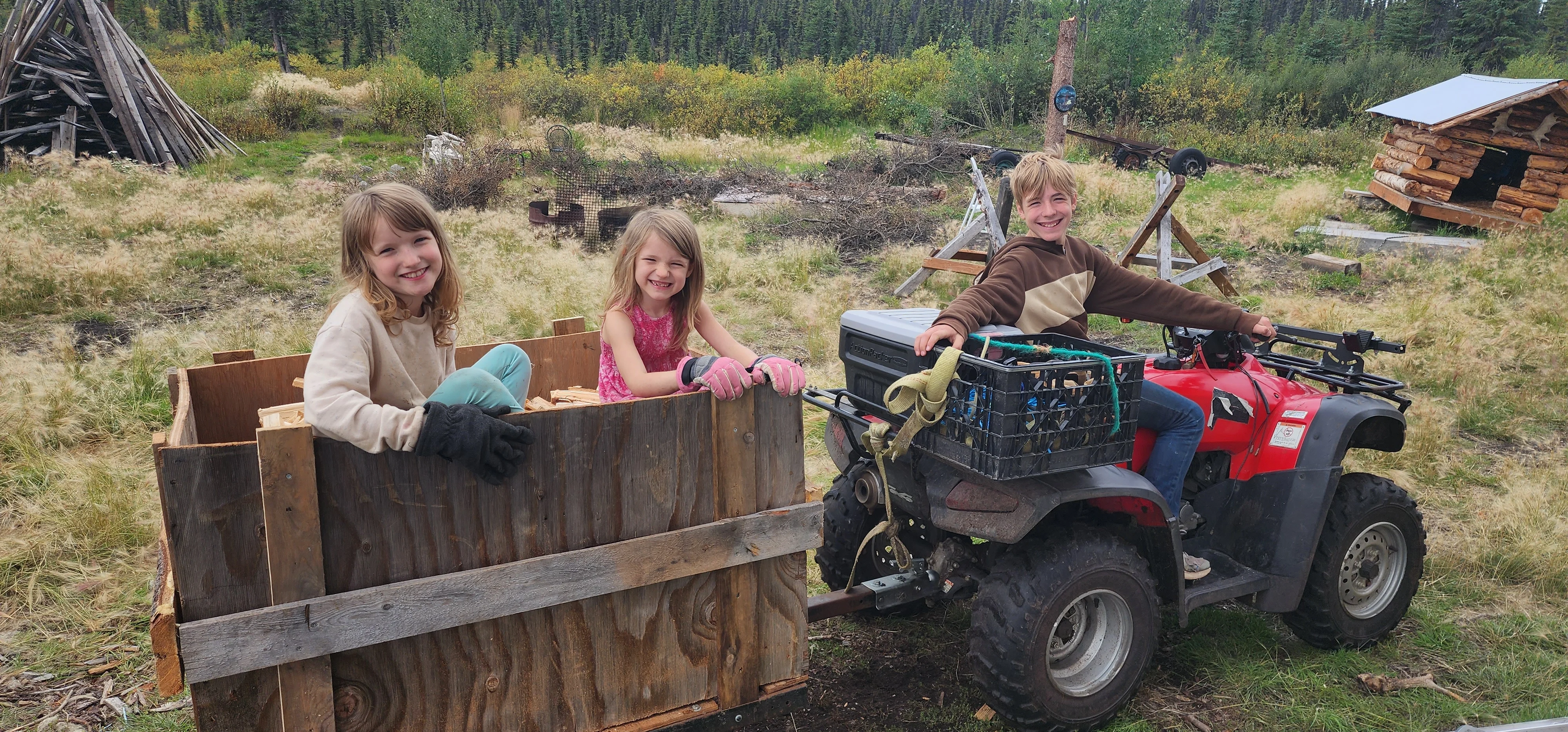 Children enjoying a fun ride on an ATV with wooden cart in a scenic outdoor setting