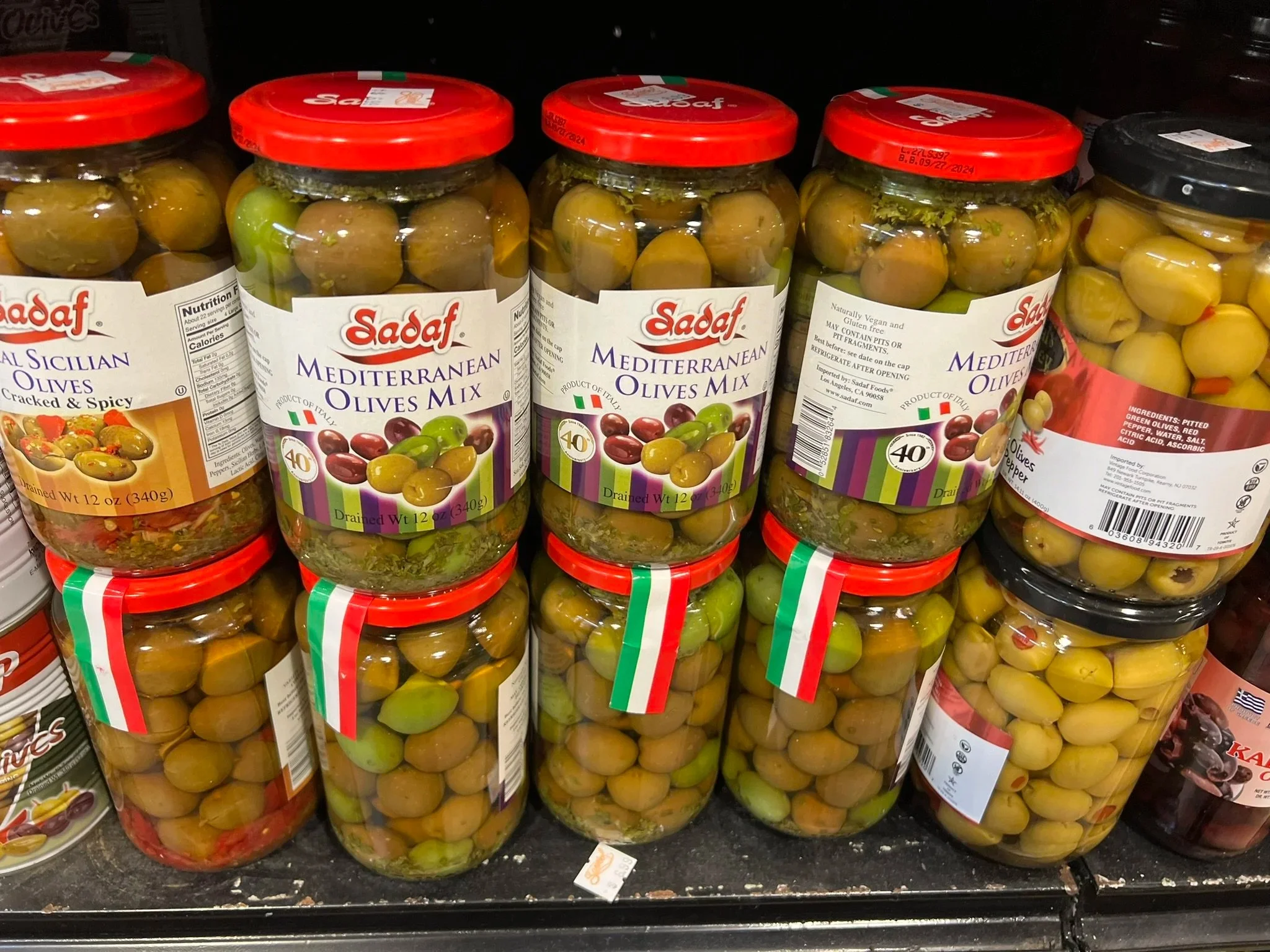 Mediterranean olives mix in jars on store shelf