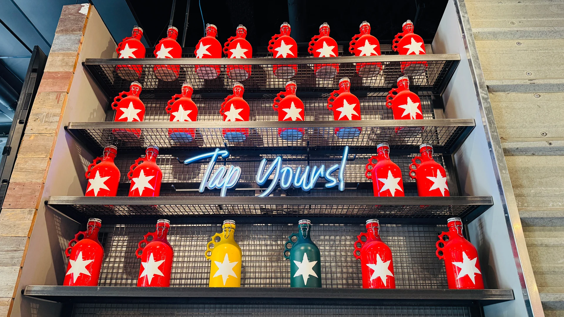 Colorful display of growlers with neon sign in a modern bar