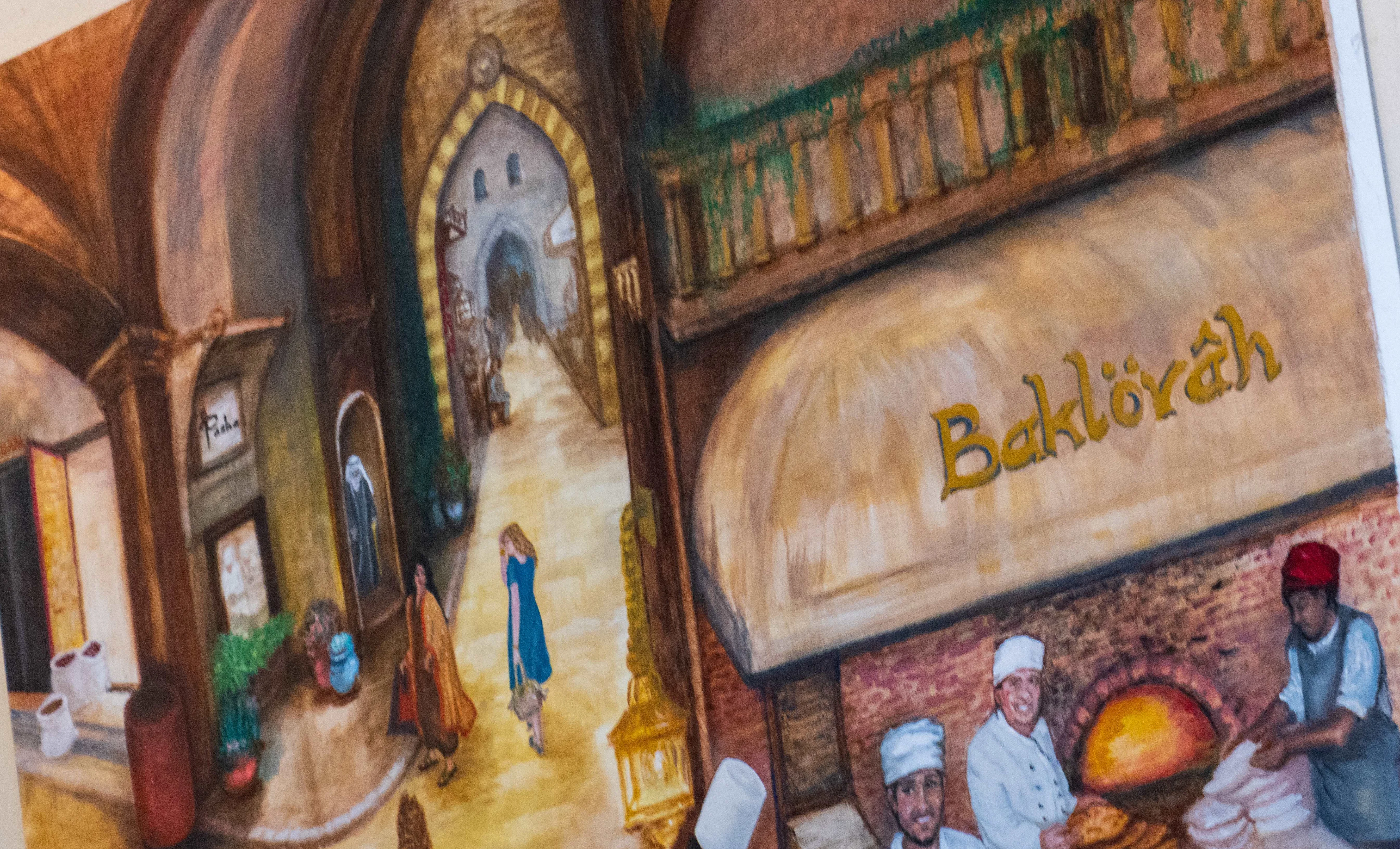 Colorful mural depicting a bustling bakery scene with bakers and customers.