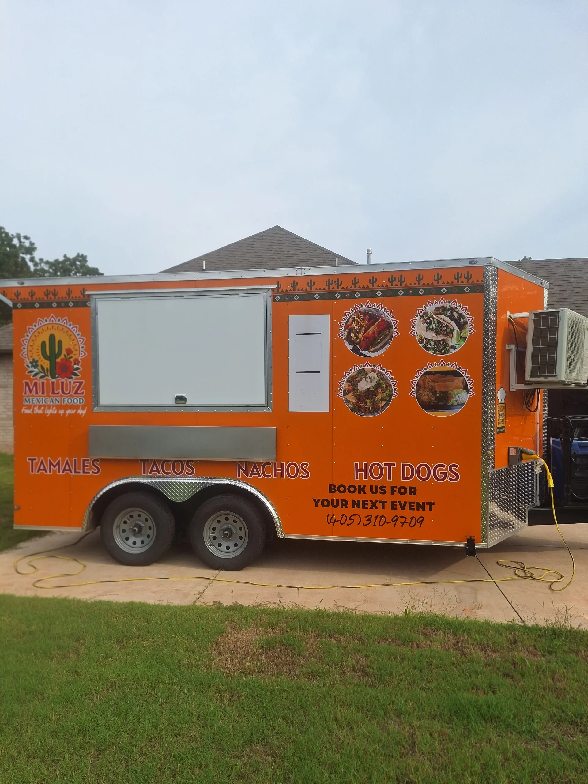 Colorful food truck offering Mexican tamales, tacos, nachos, and hot dogs