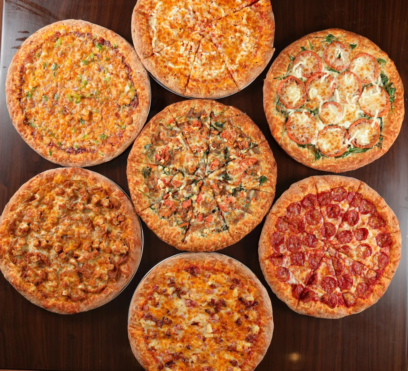 Variety of gourmet pizzas on a wooden table