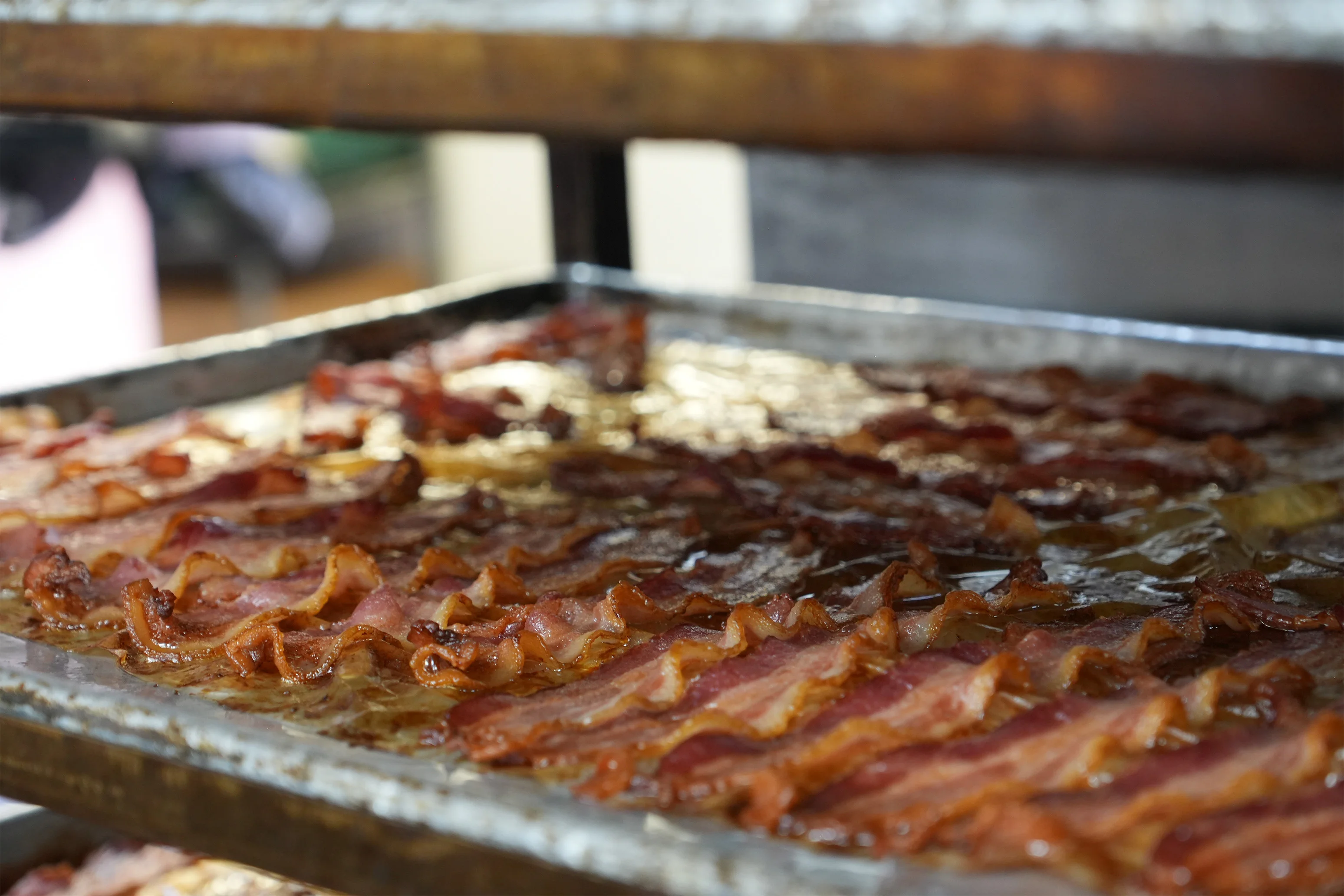 Crispy bacon sizzling on a restaurant griddle