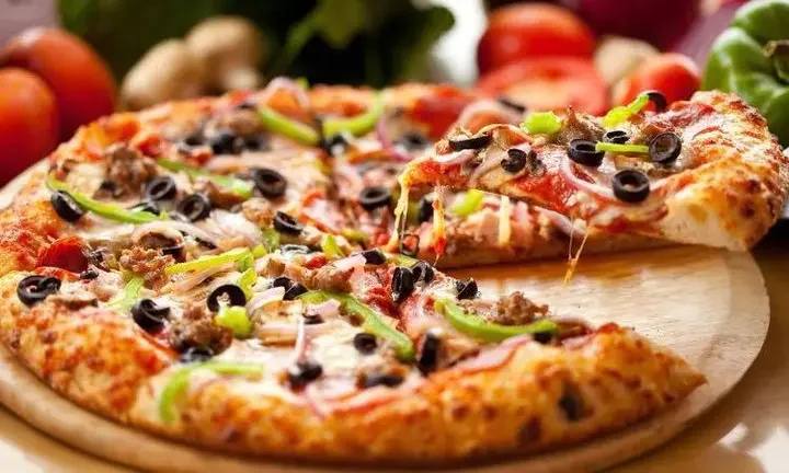 Delicious pizza with fresh toppings on a wooden table