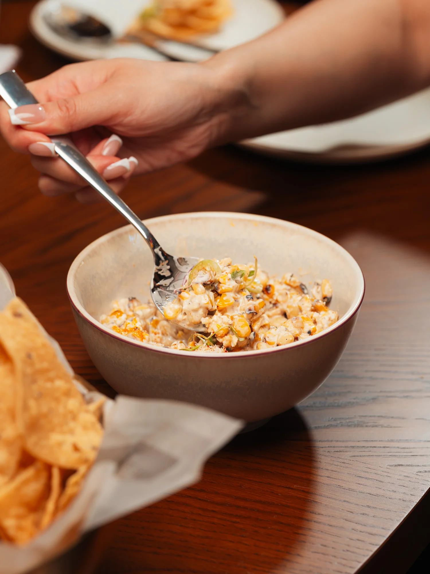 Bowl of Mexican elote with creamy sauce and toppings