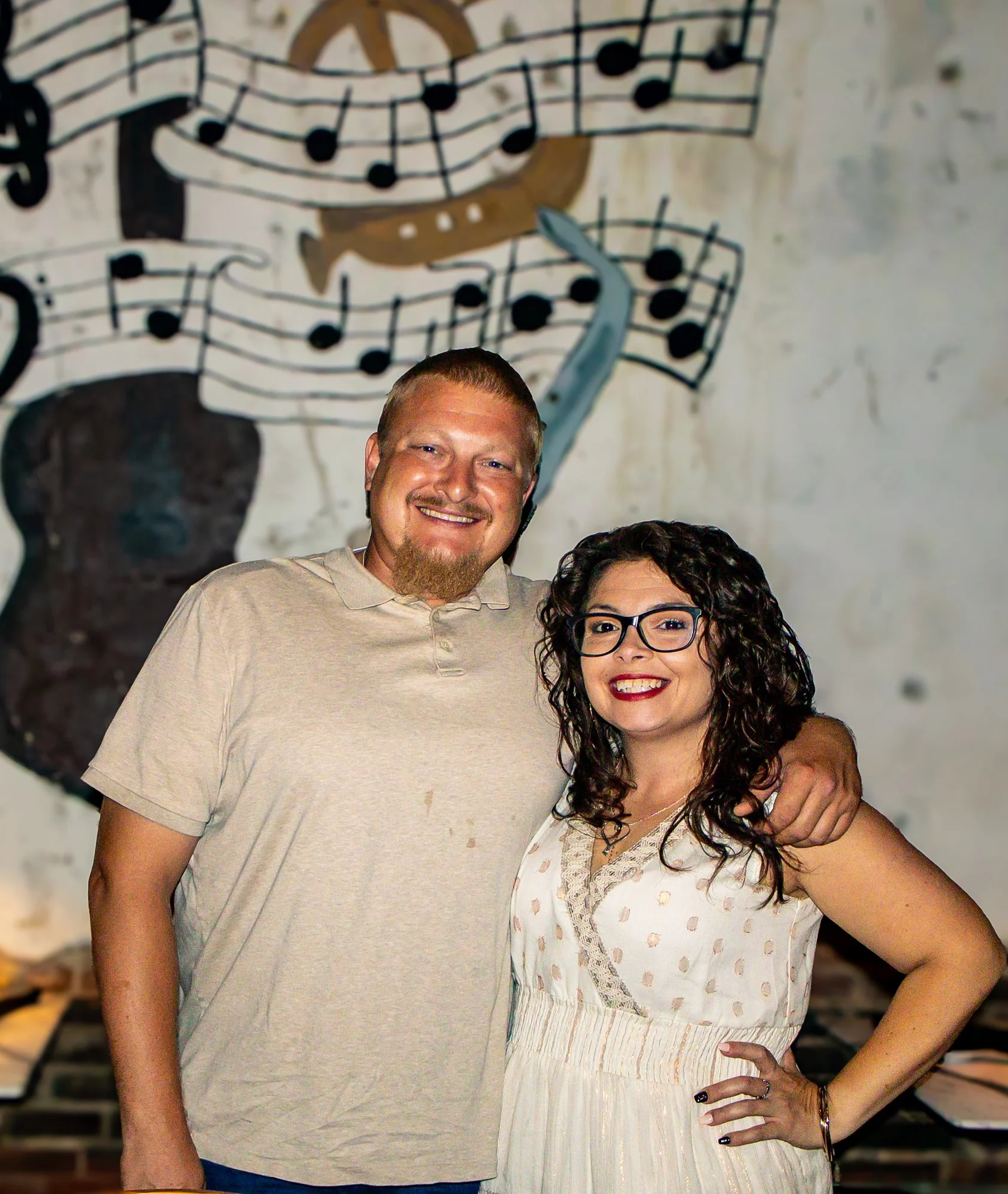 Couple posing in a cozy restaurant with musical decor
