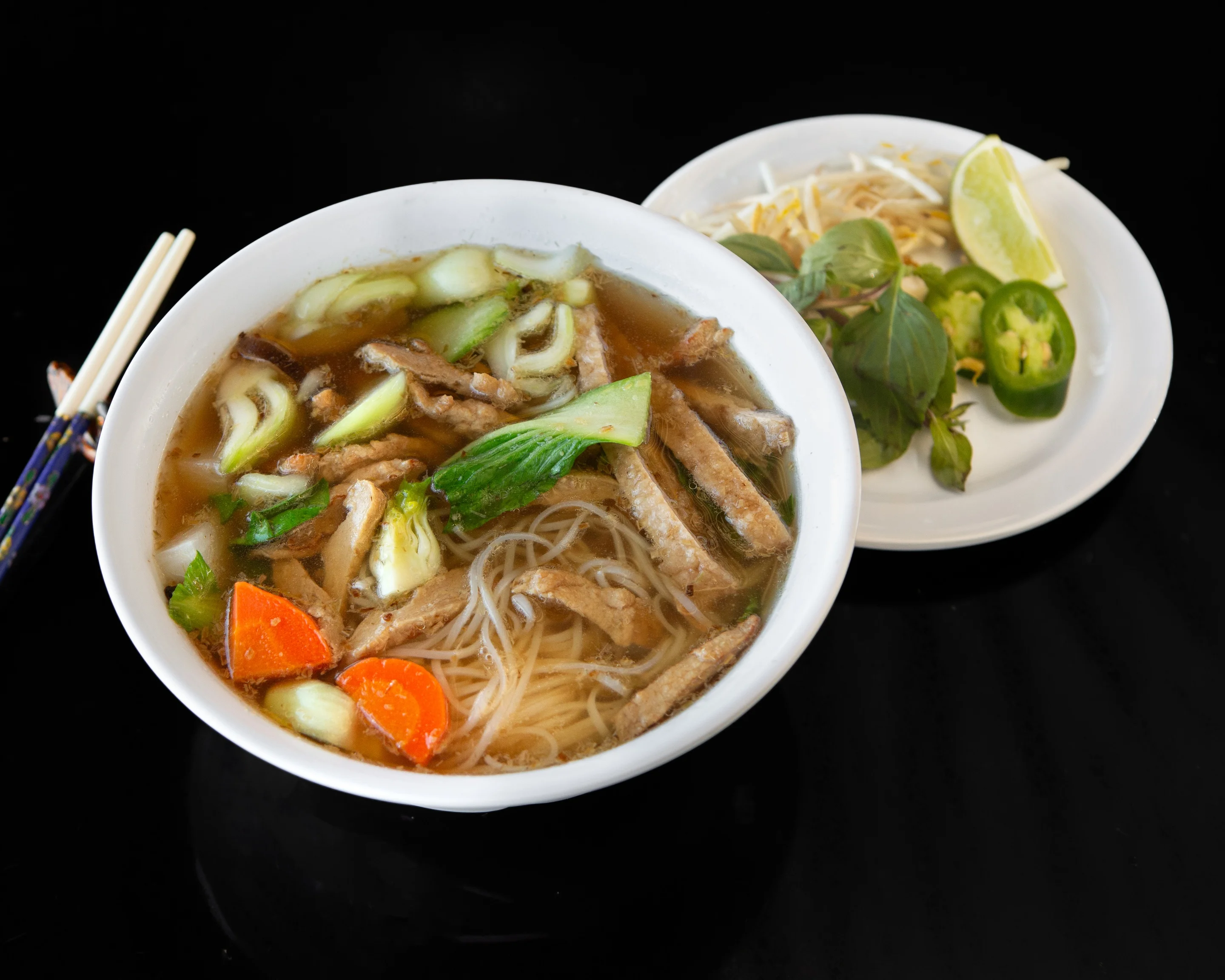 Bowl of Vietnamese pho with beef and fresh herbs