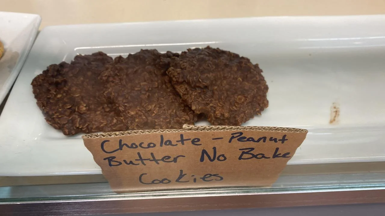 A display of chocolate-peanut butter no bake cookies placed on a white plate with a label.