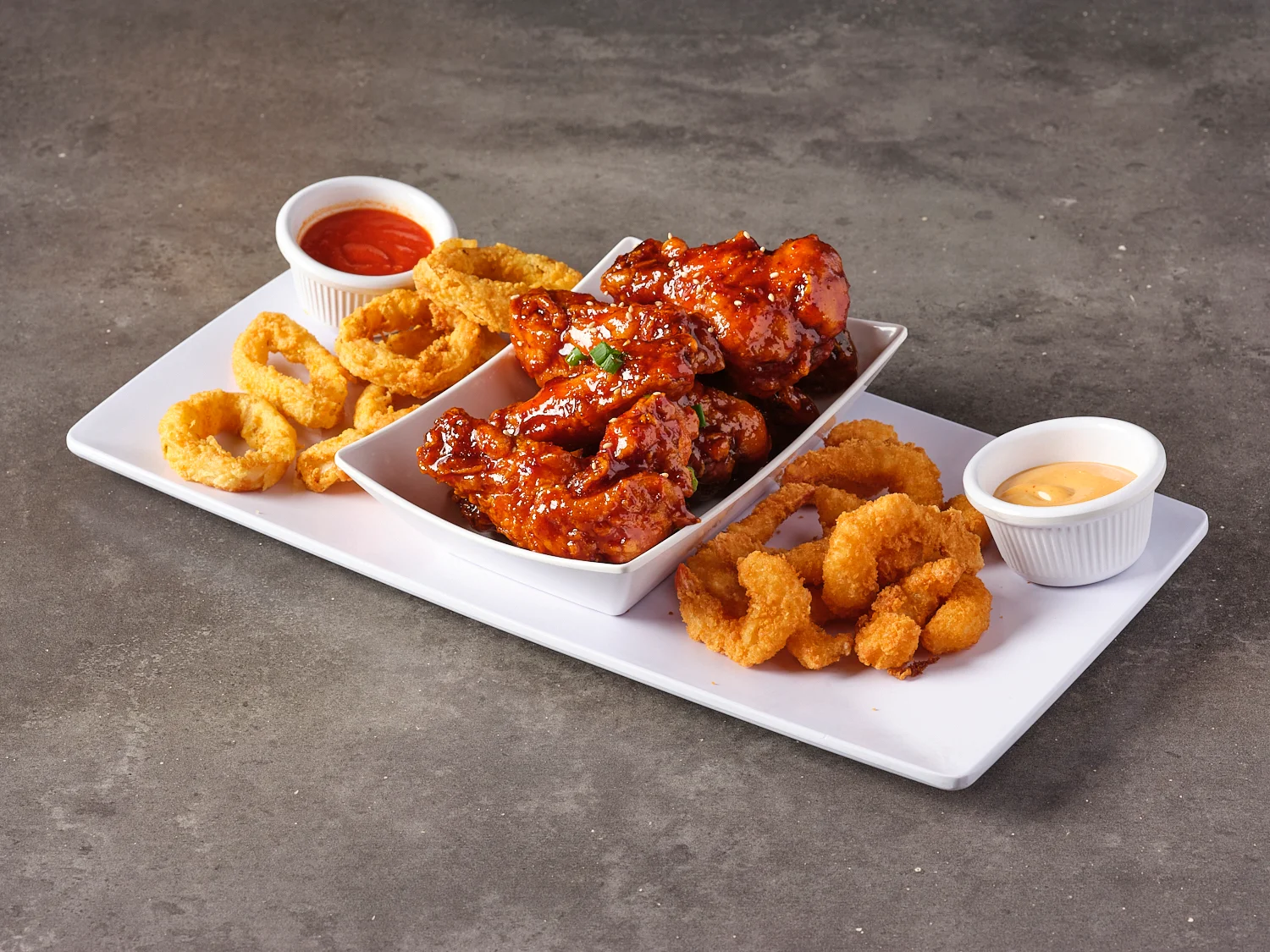 Crispy buffalo wings with onion rings and dipping sauces