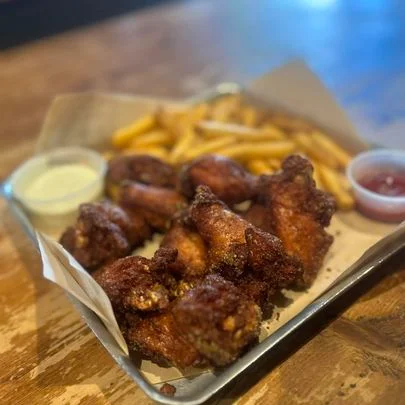 Crispy chicken wings with fries and dipping sauces