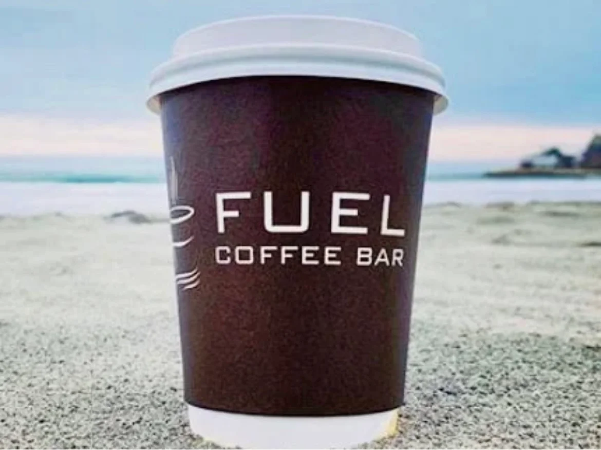 Coffee cup from Fuel Coffee Bar on sandy beach