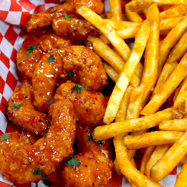 A delicious serving of shrimp and fries on a plate.