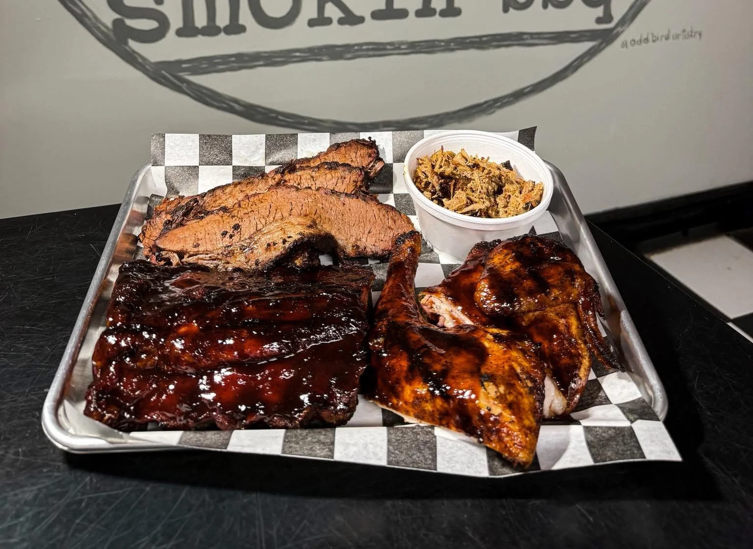 Platter of BBQ ribs, brisket, chicken, and sides at Big Mike's Smokin' BBQ.